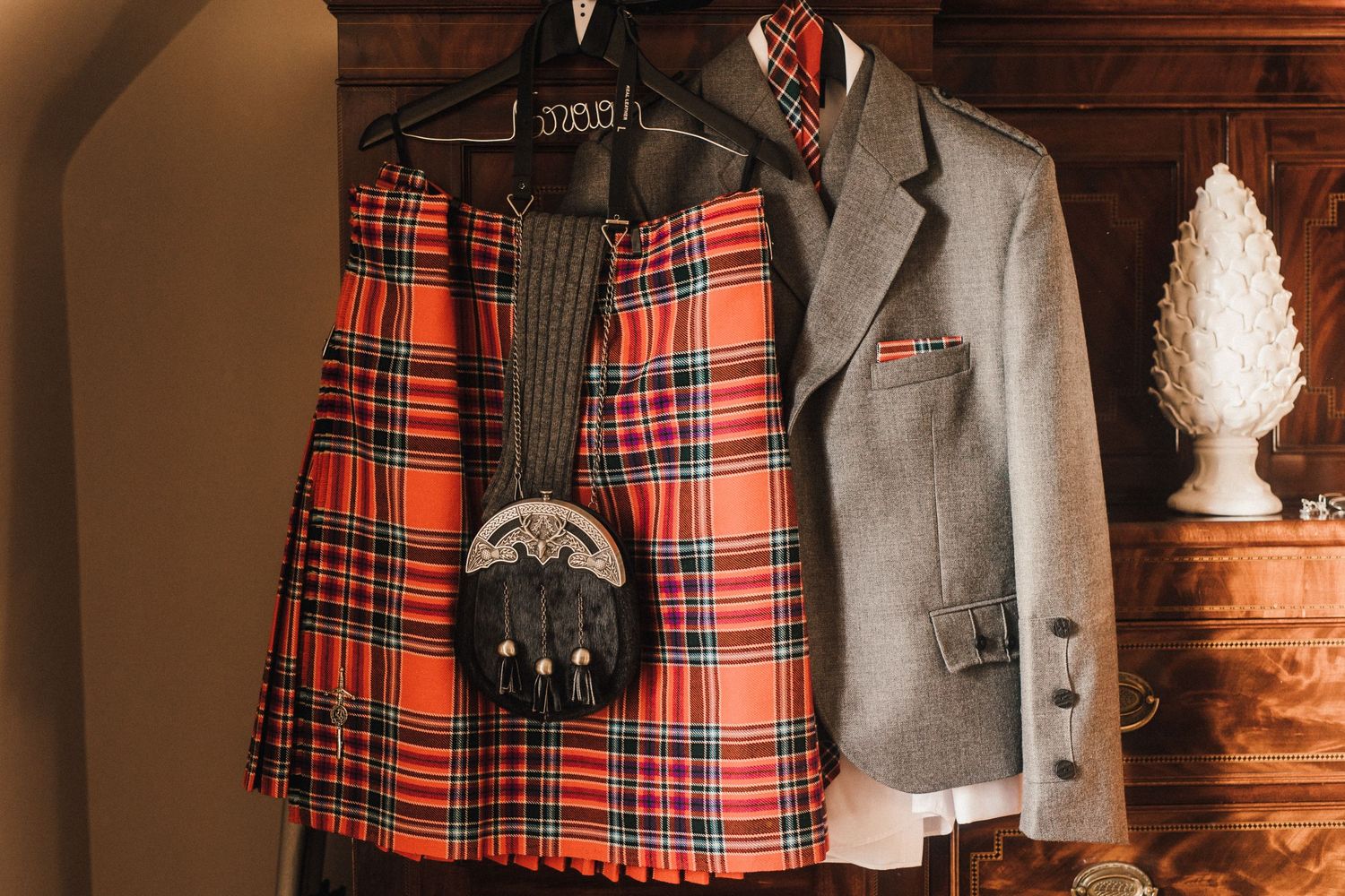 Traditional Scottish wedding attire with tartan kilt and sporran hanging on display.
