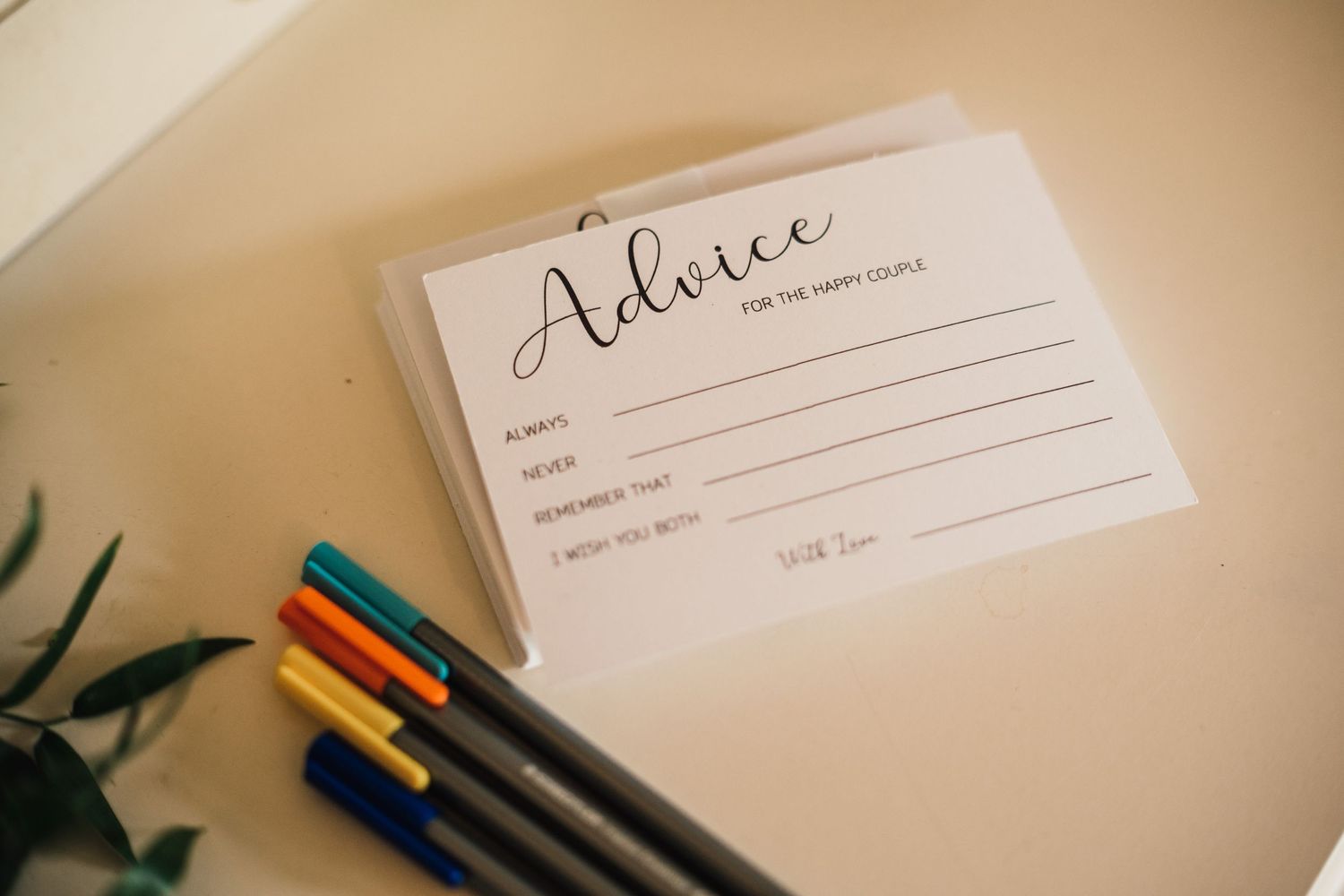 Wedding advice card with colorful pens ready for guests to write messages.