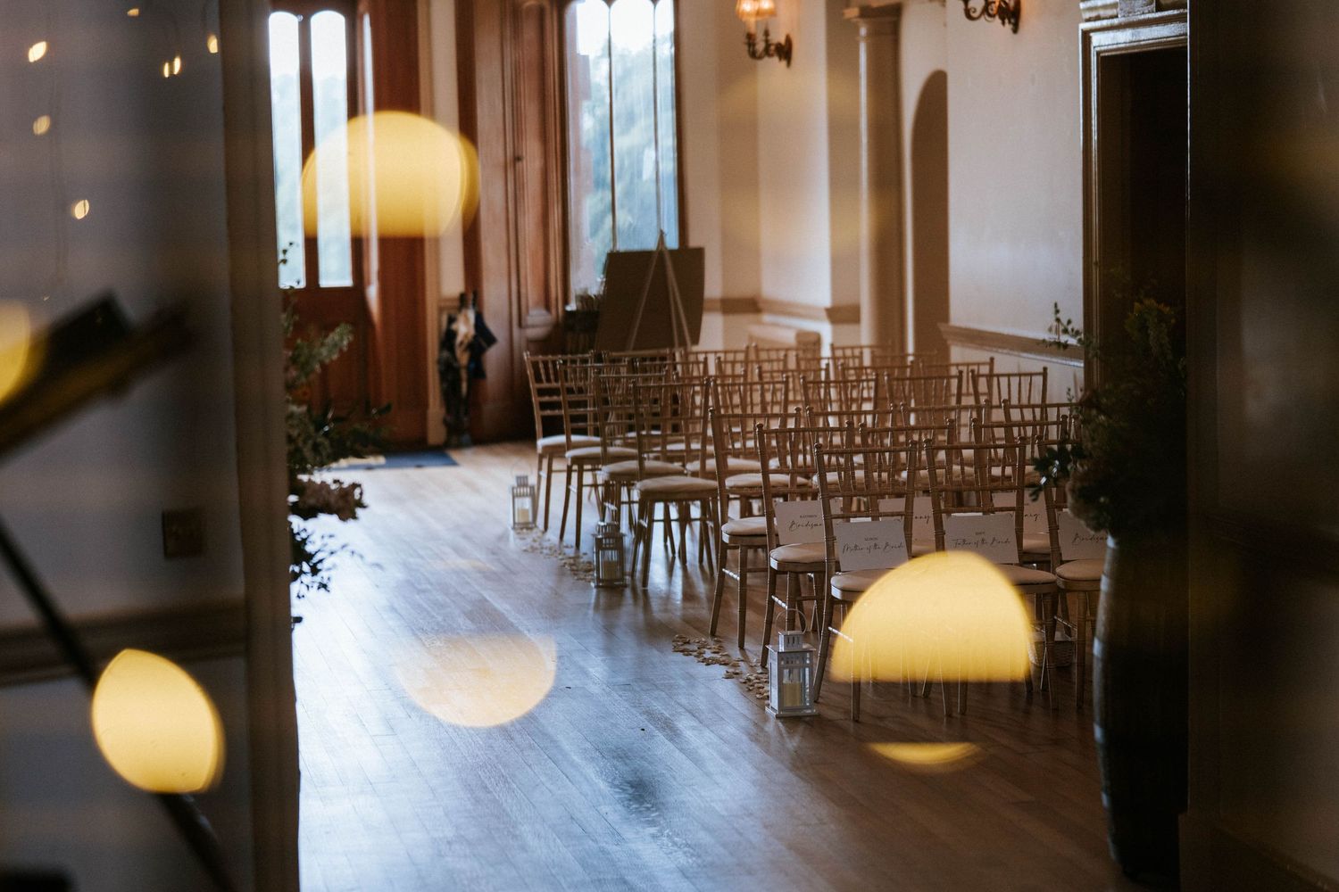 Empty wedding ceremony space with rows of chairs and natural light streaming through windows.