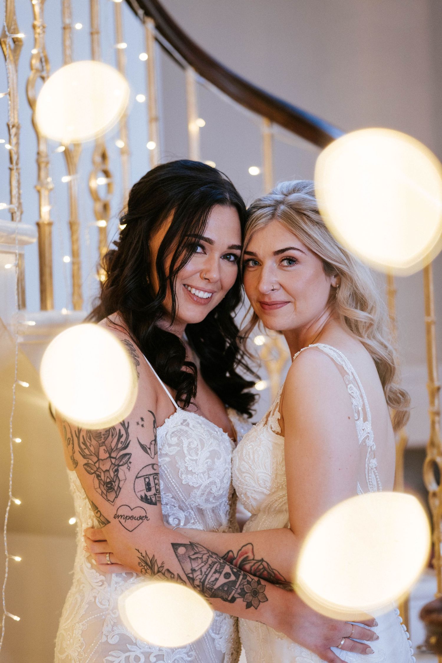 Indoor wedding portrait with romantic string lights and bokeh effects in the background.