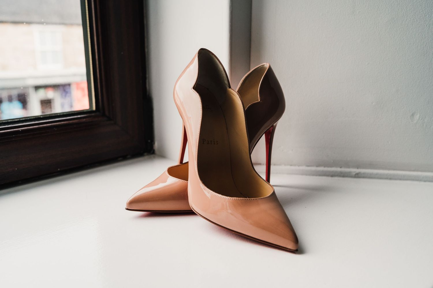 A pair of elegant nude high heel shoes photographed from different angles against a white background.