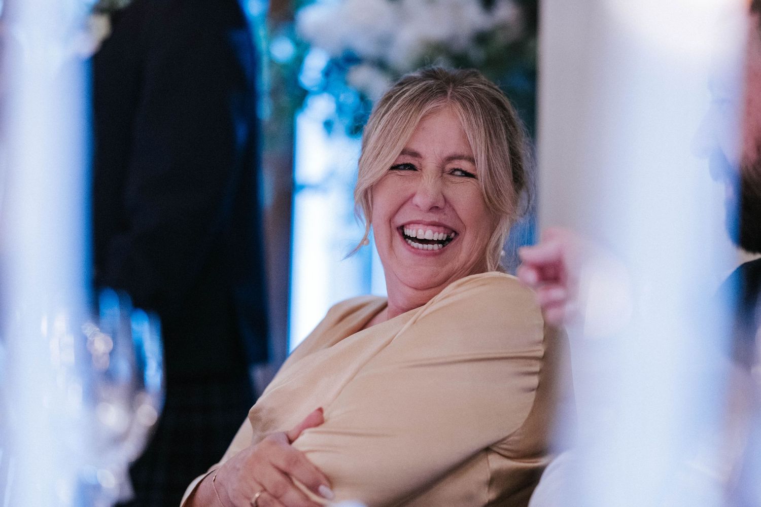 Wedding guests share emotional embraces and joyful reactions during reception celebrations.