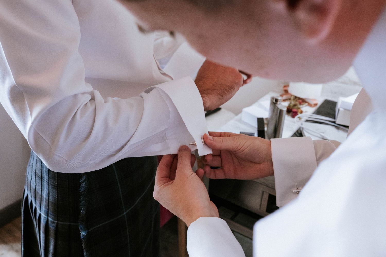 Close-up shots of men adjusting formal wear and buttons before an event.