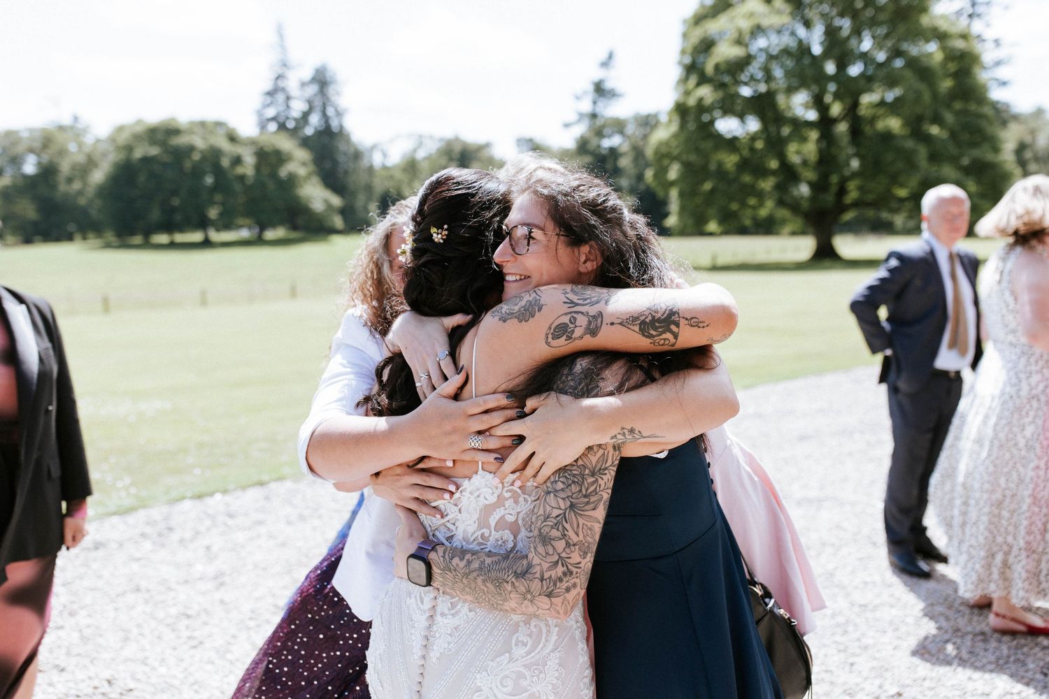 Fasque Castle Wedding Photography. Wedding guests gather for celebratory hugs and congratulations on a gravel path.