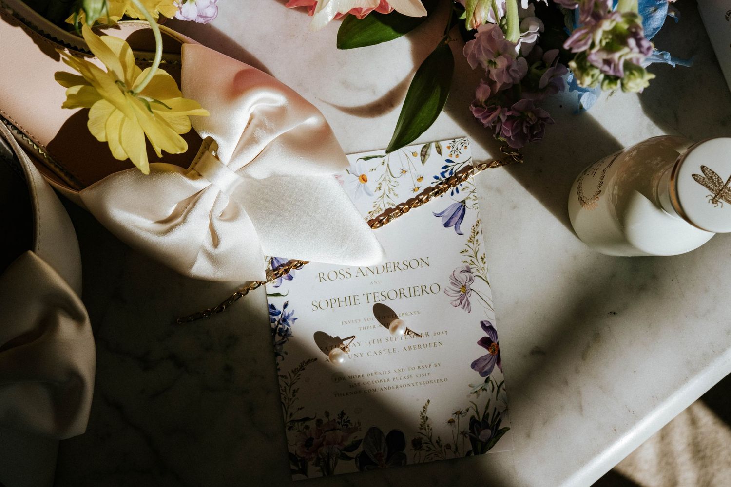 Wedding invitation and floral details arranged artistically in natural light.