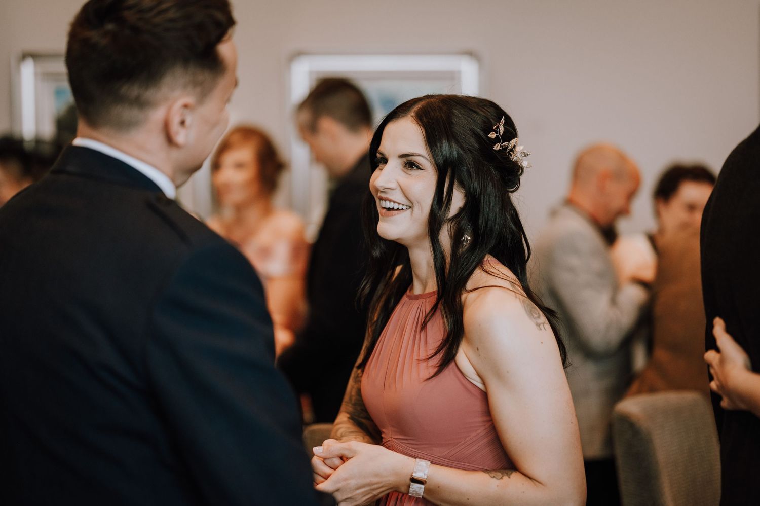 Wedding guests engaged in animated conversation during the reception.