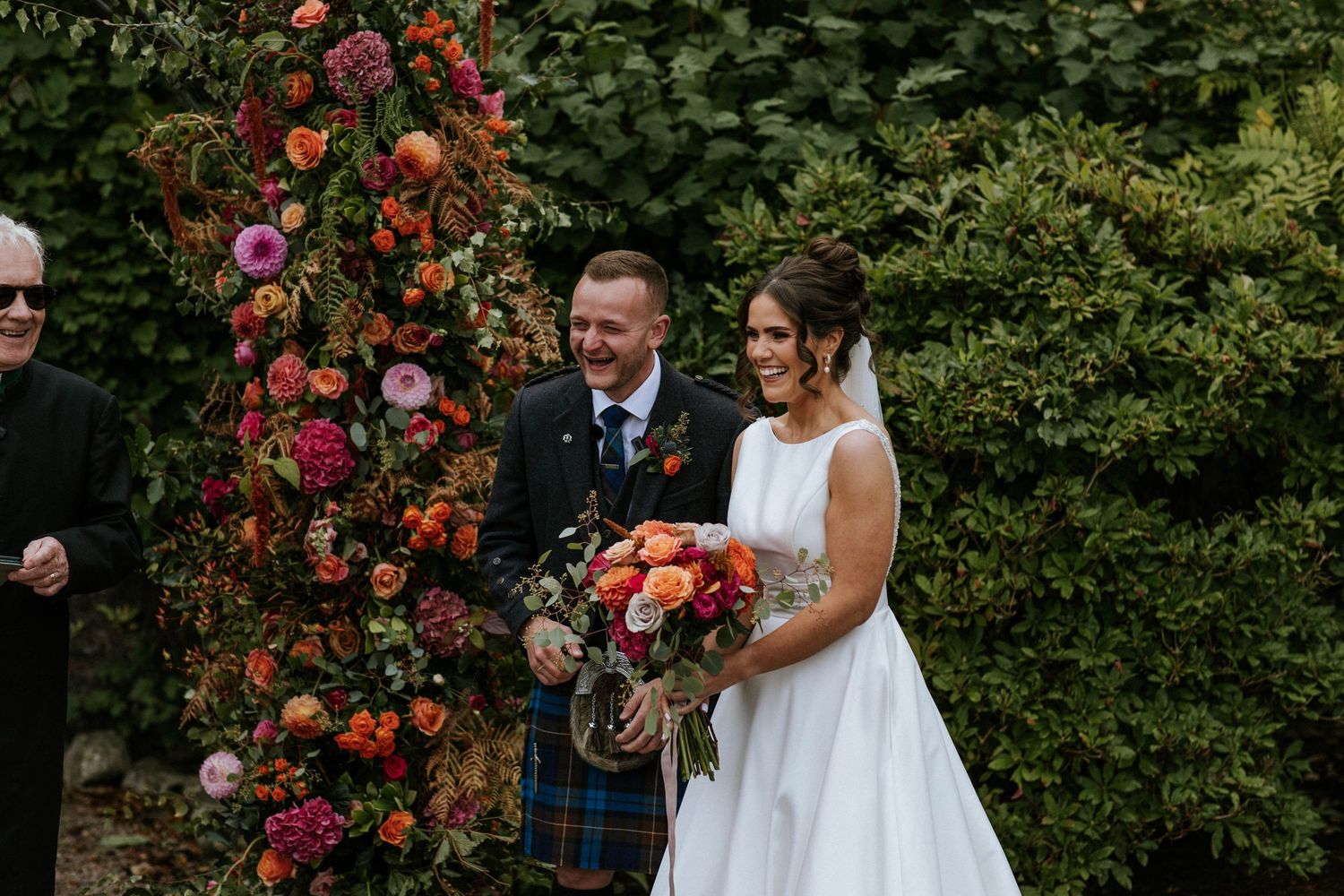 Garden wedding scene with vibrant red flowers and greenery.