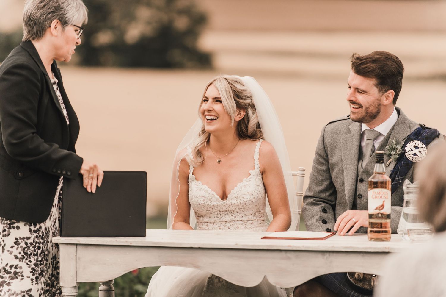A joyful moment during the wedding document signing at an outdoor ceremony.