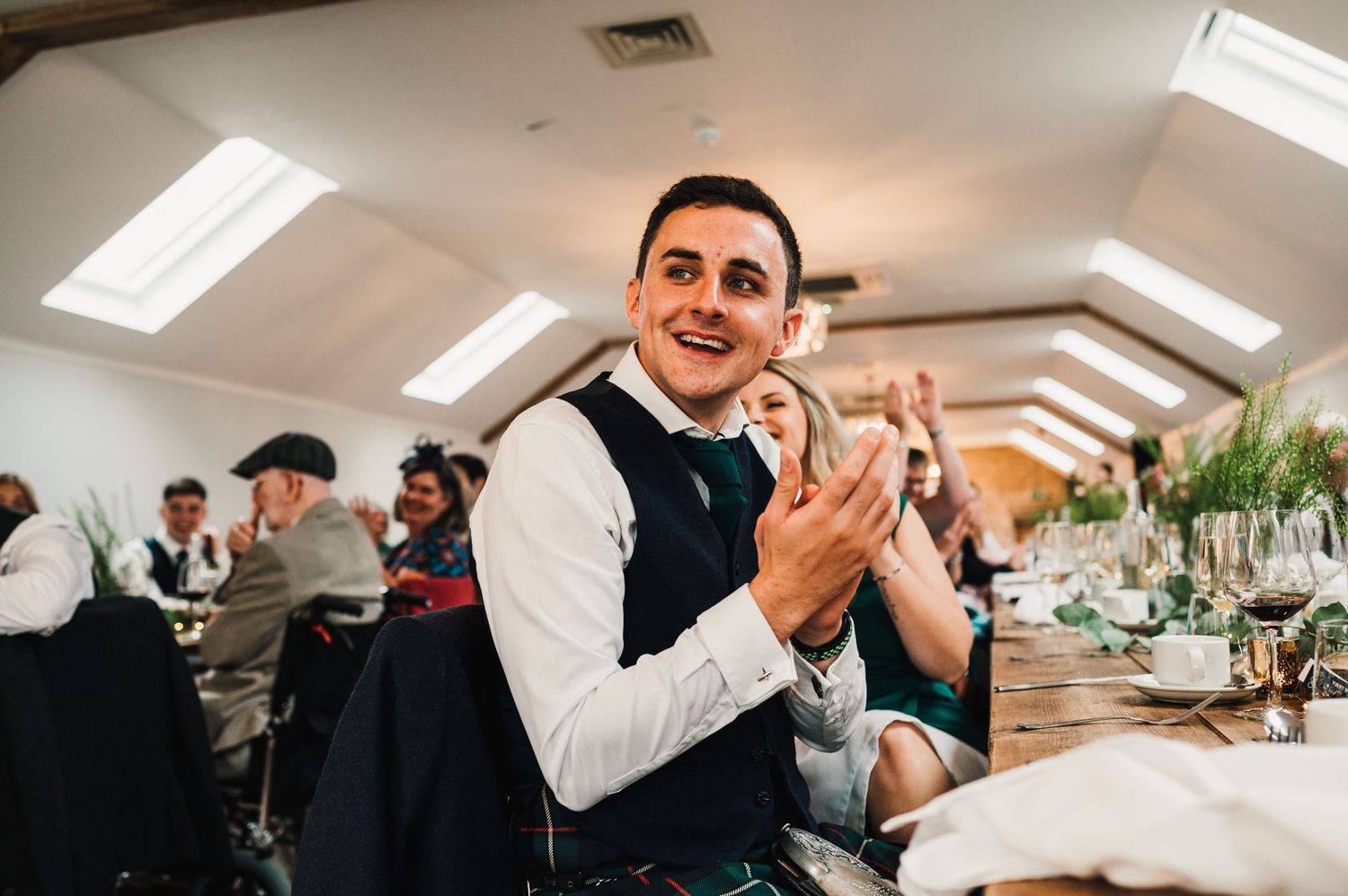Wedding guest claps enthusiastically during reception celebration.