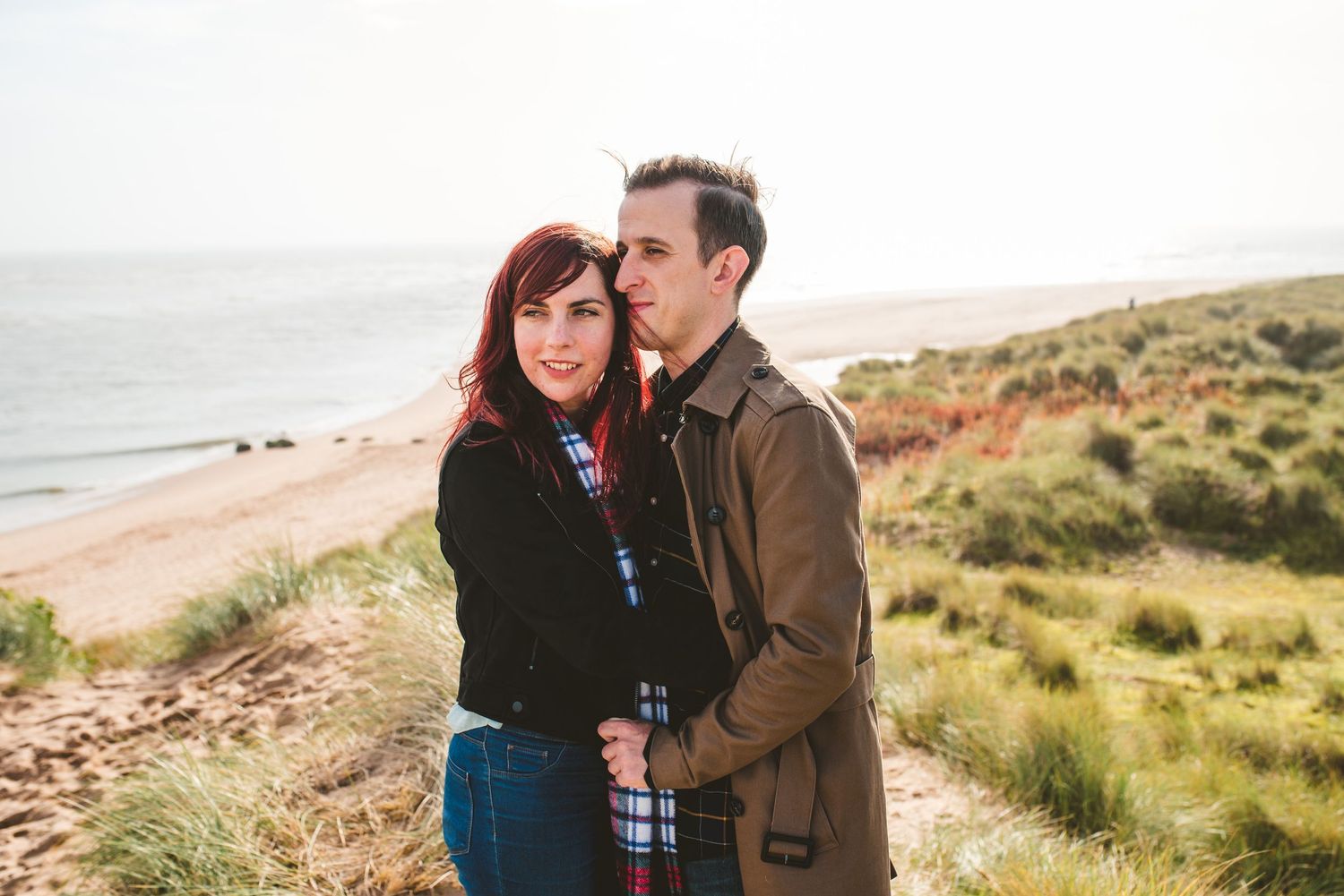 A romantic moment shared between a couple on a scenic coastal overlook.