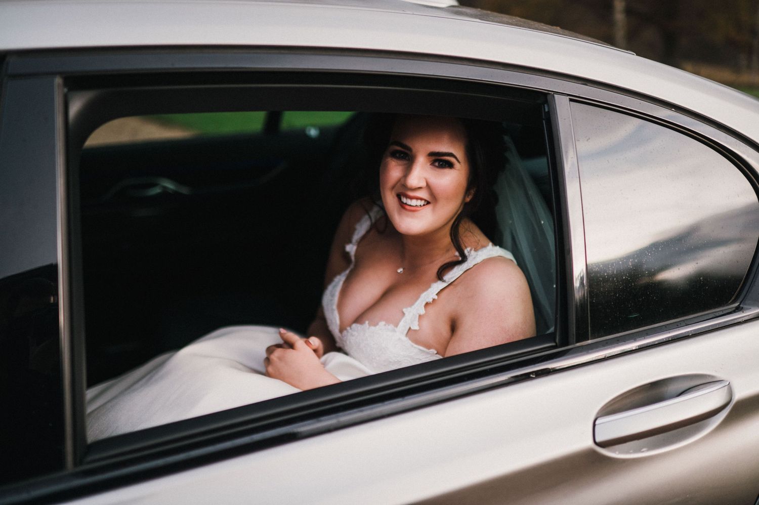 A passenger looking out from a luxury car window.