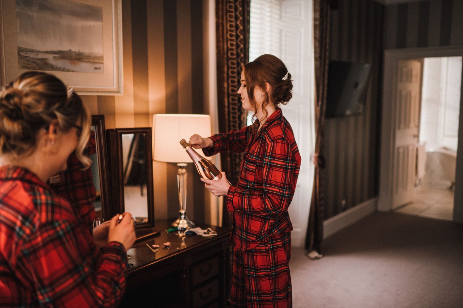 People in matching red plaid robes getting ready at a dressing table.
