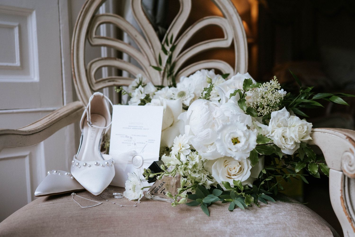 White floral wedding decorations and table settings in an elegant indoor venue.
