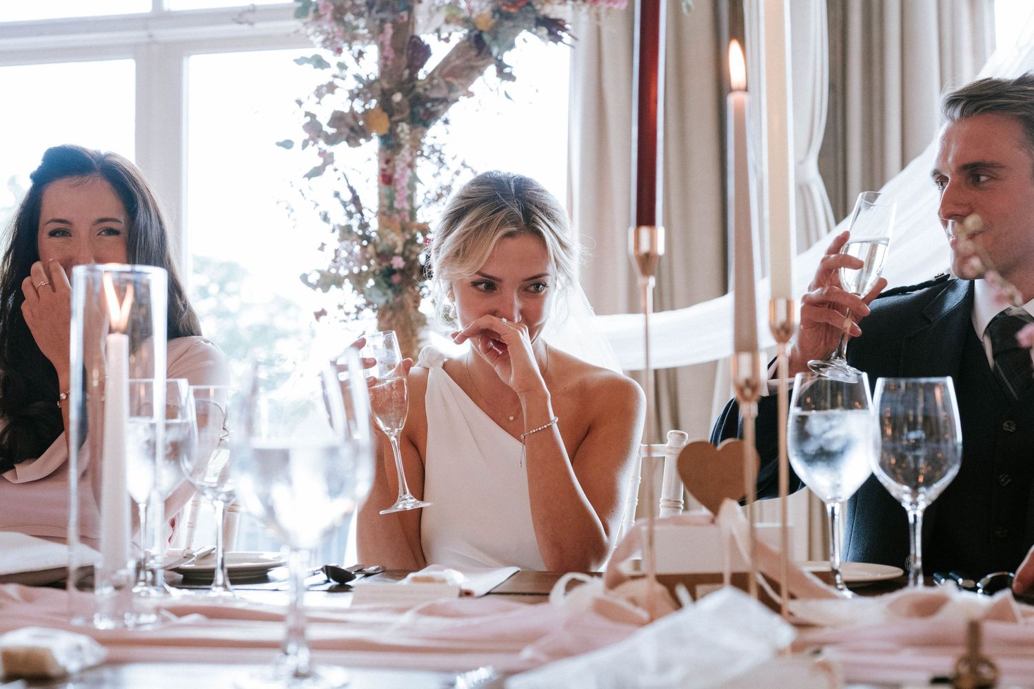 Wedding reception guests enjoying drinks and conversation at an elegant table setting.