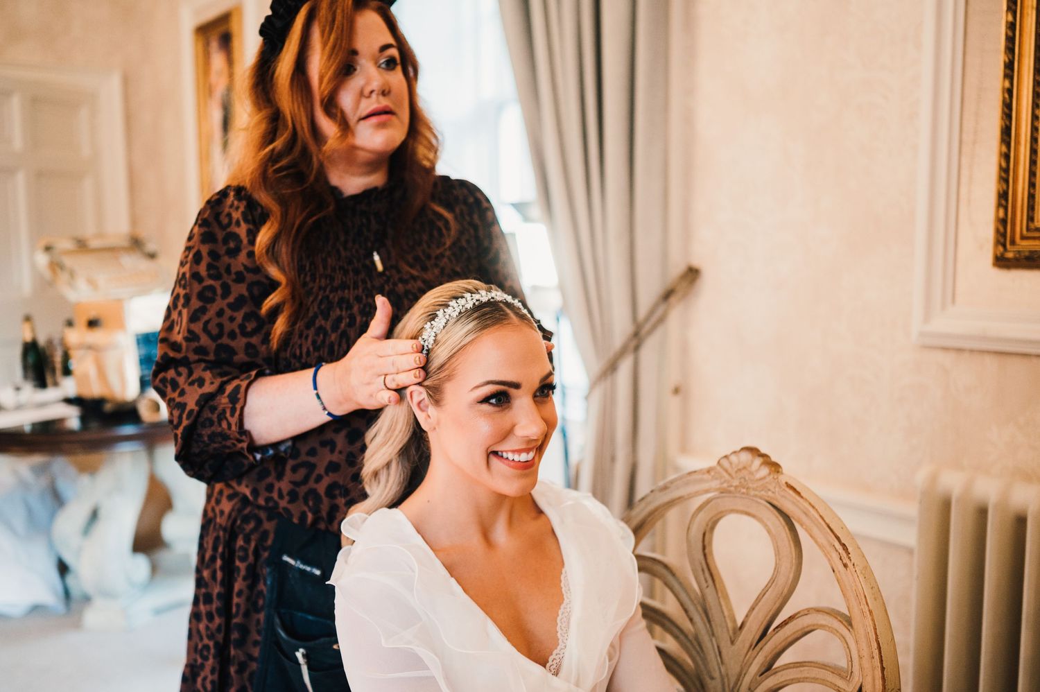 Wedding preparation scene showing styling session in elegant room.