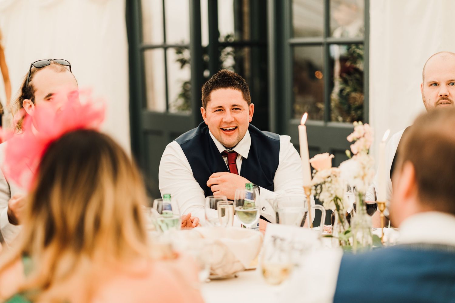 Candid moment of joyful conversation during a wedding reception dinner.
