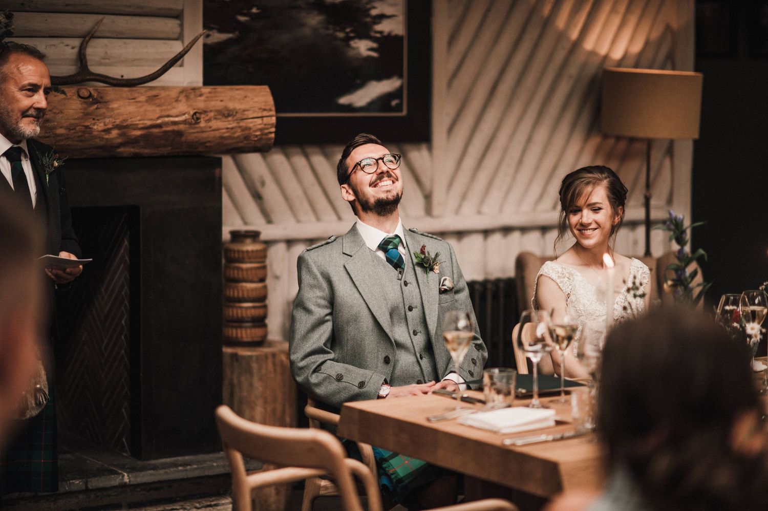 Reception celebration in rustic lodge setting with wooden beams and decorative florals.