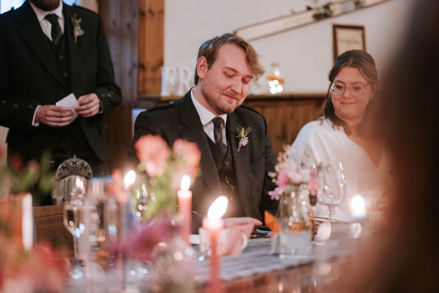 Wedding reception dinner table with candlelight and elegant place settings.