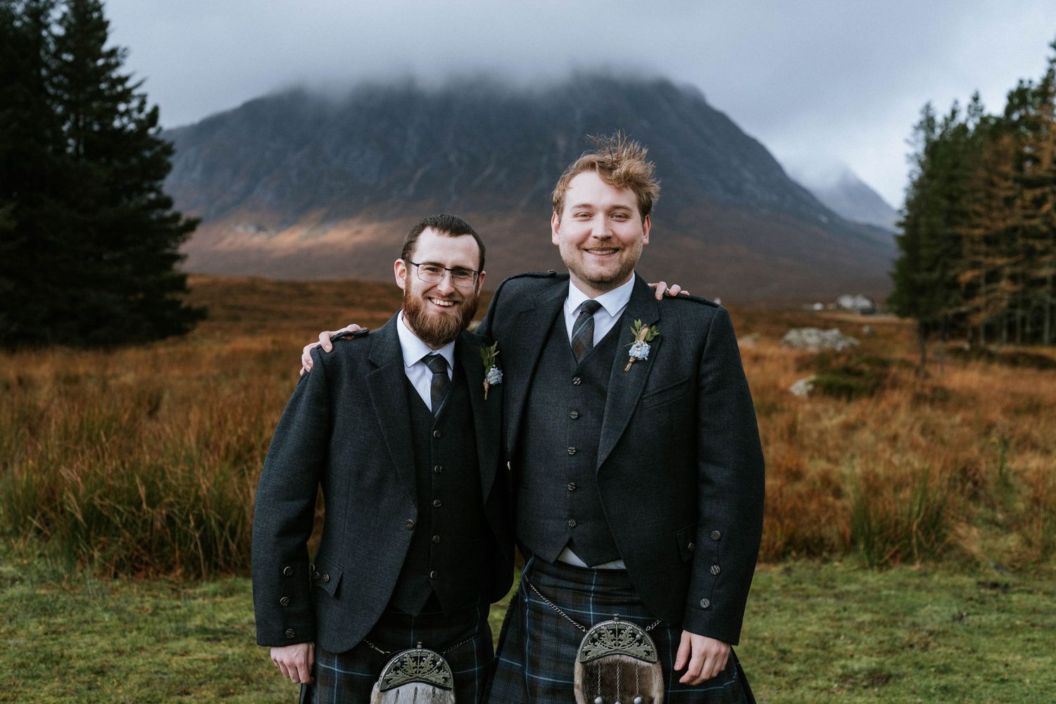Scenic mountain wedding photography with evergreen trees and misty peaks in the background.