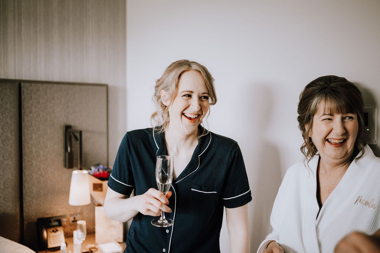 Joyful moment captured during wedding preparation with matching robes.