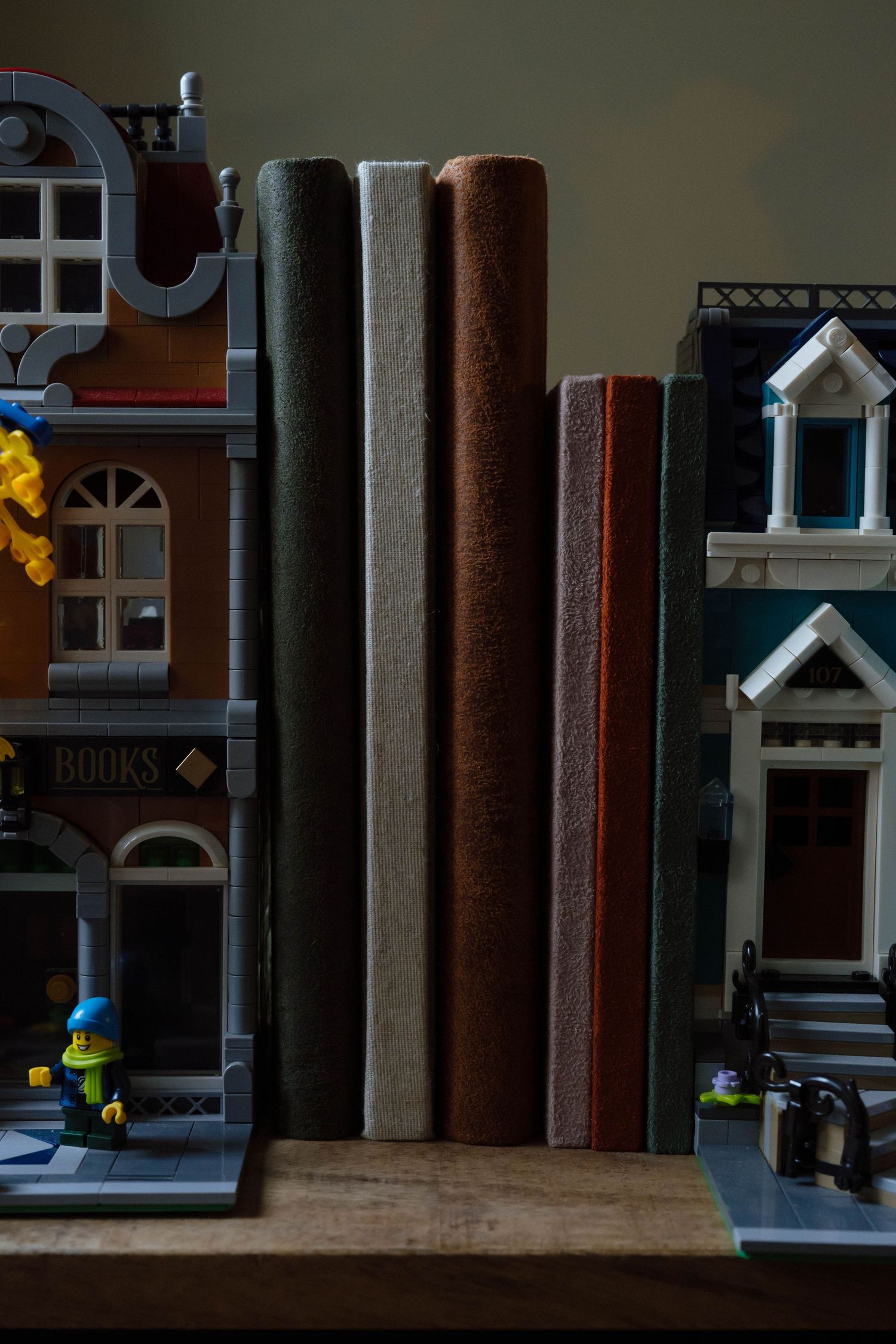 Close-up of miniature LEGO buildings and architectural details on a dark bookshelf.