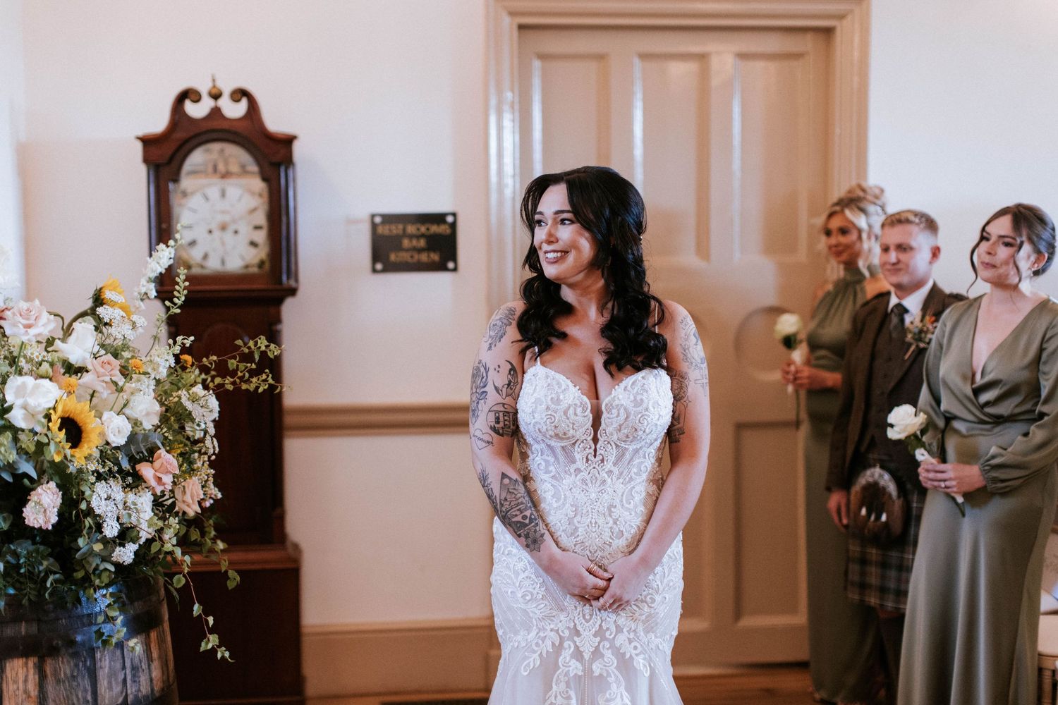 Wedding ceremony moments captured in an elegant white venue with floral decorations.