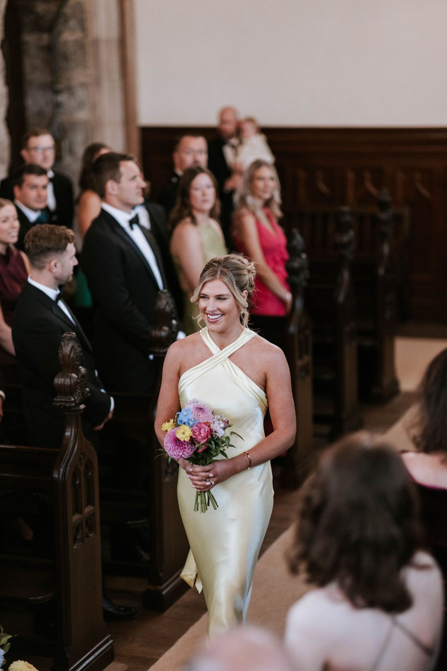 Joyful wedding ceremony moment with guests looking on in church sanctuary.