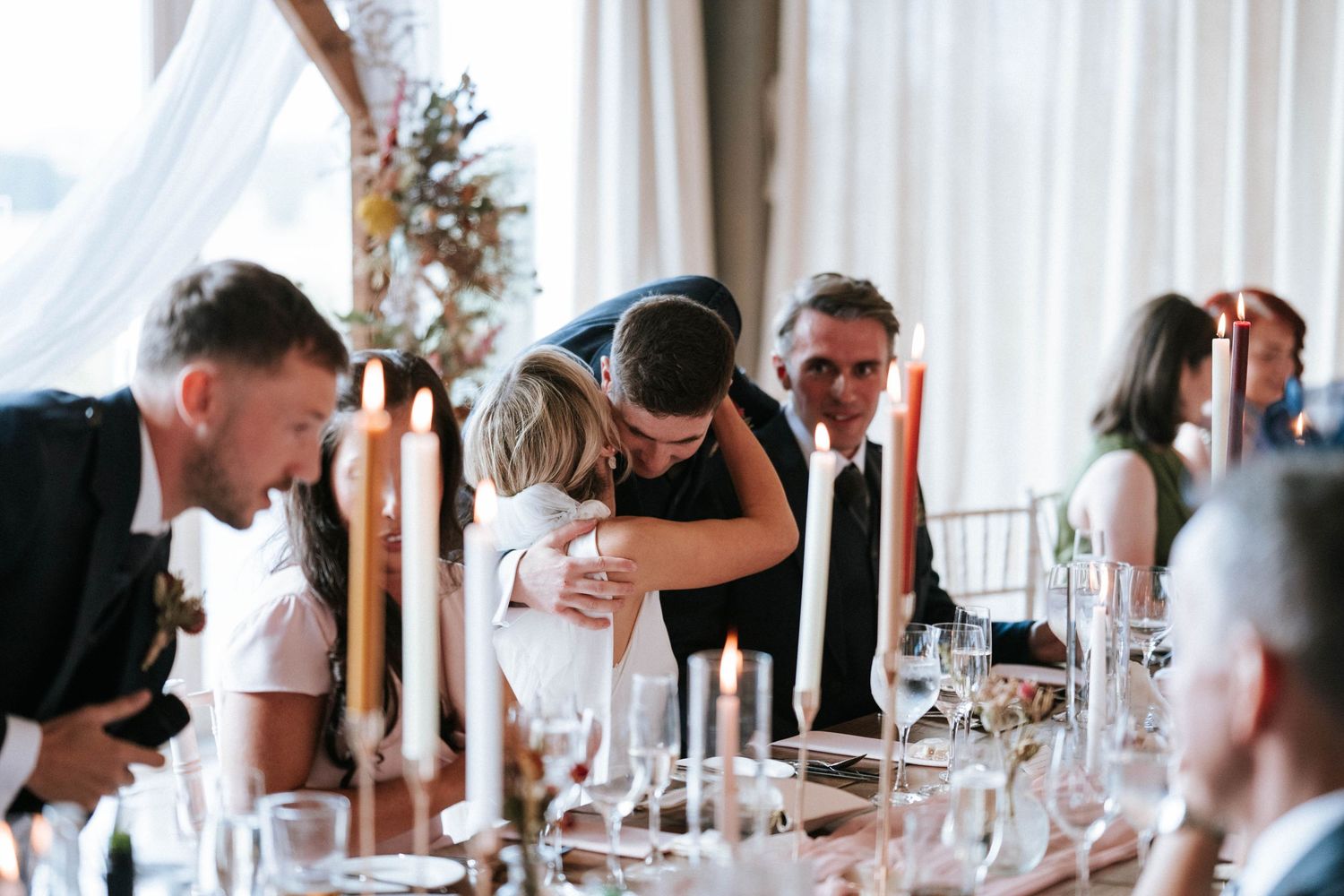 Emotional moment shared between guests during wedding reception dinner.