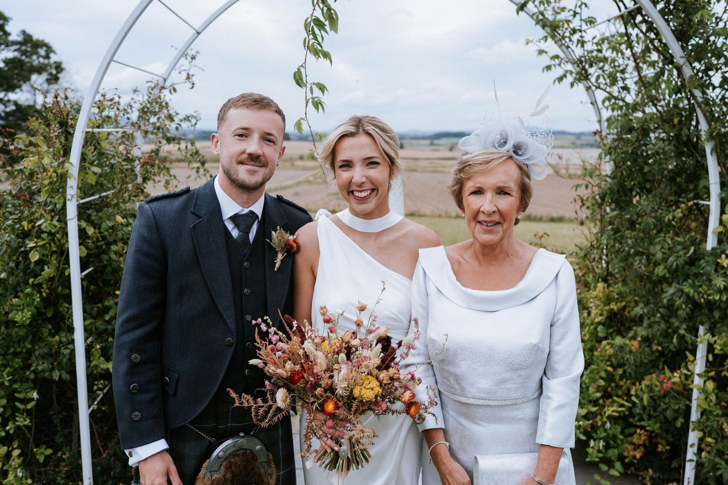 Outdoor wedding portraits with autumn-colored bouquets and natural scenery.