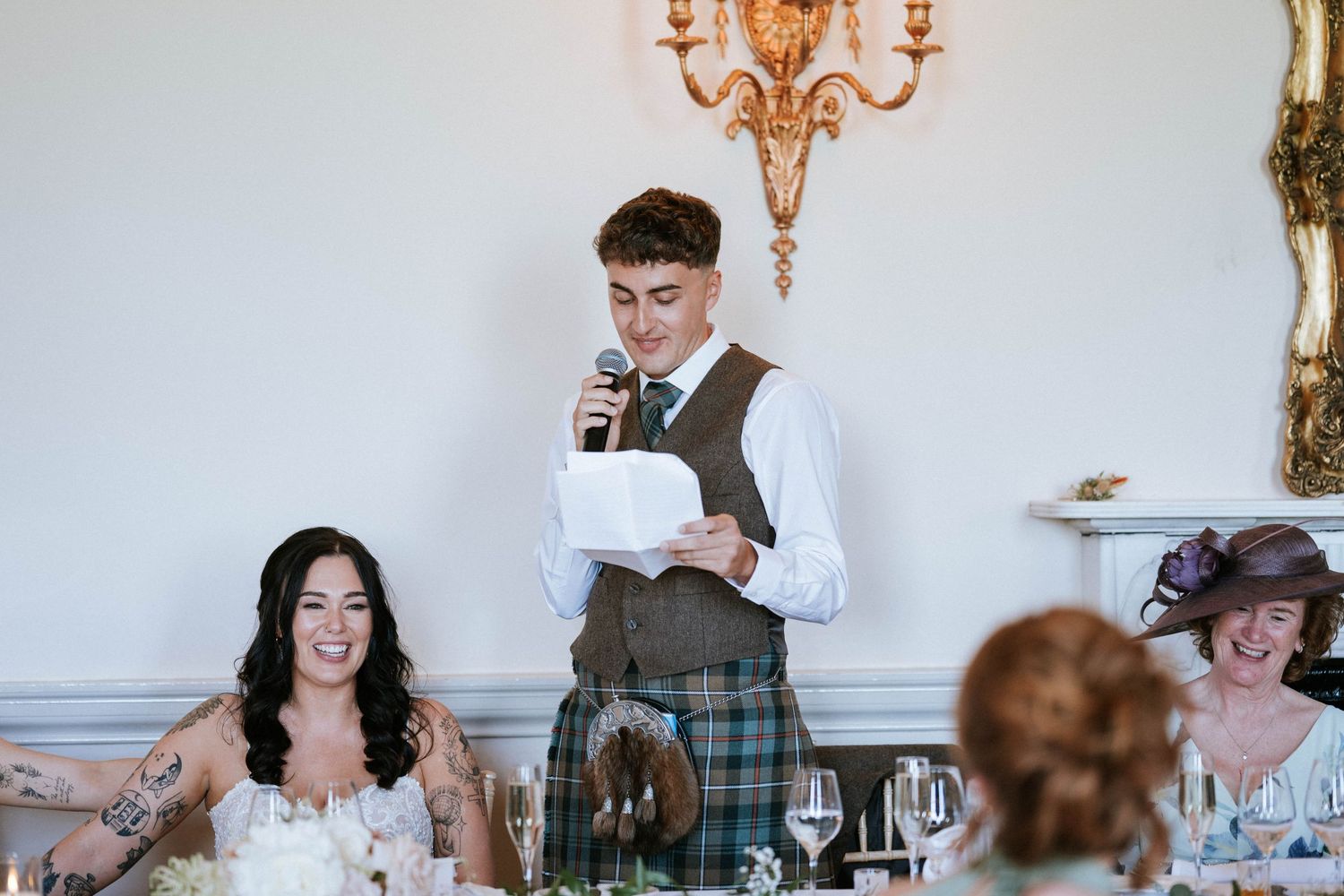 Fasque Castle Wedding Photography. Guests and wedding party members celebrate with drinks at an elegant reception venue.