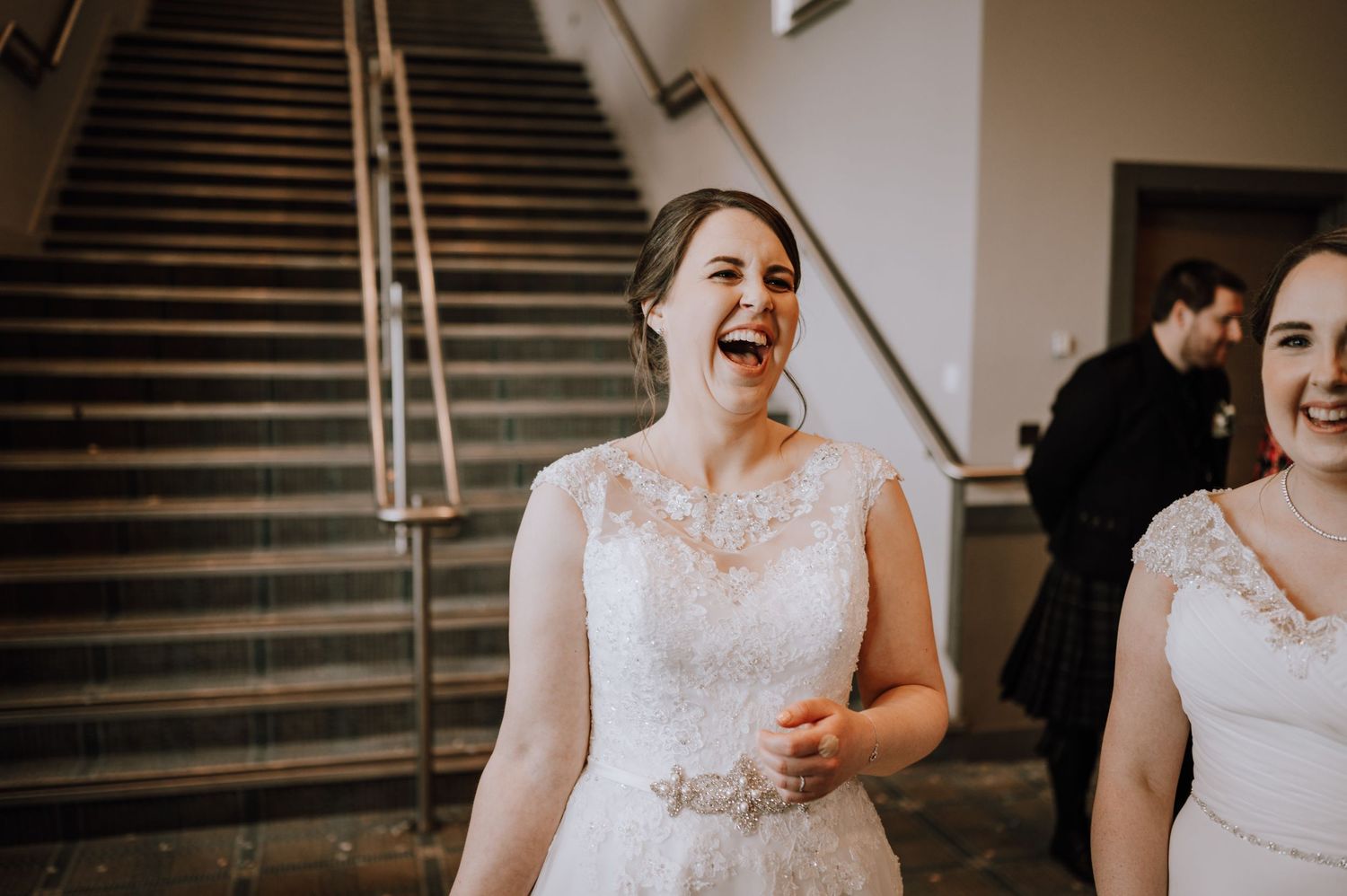 Joyful celebration moment captured on a grand staircase during a wedding reception.