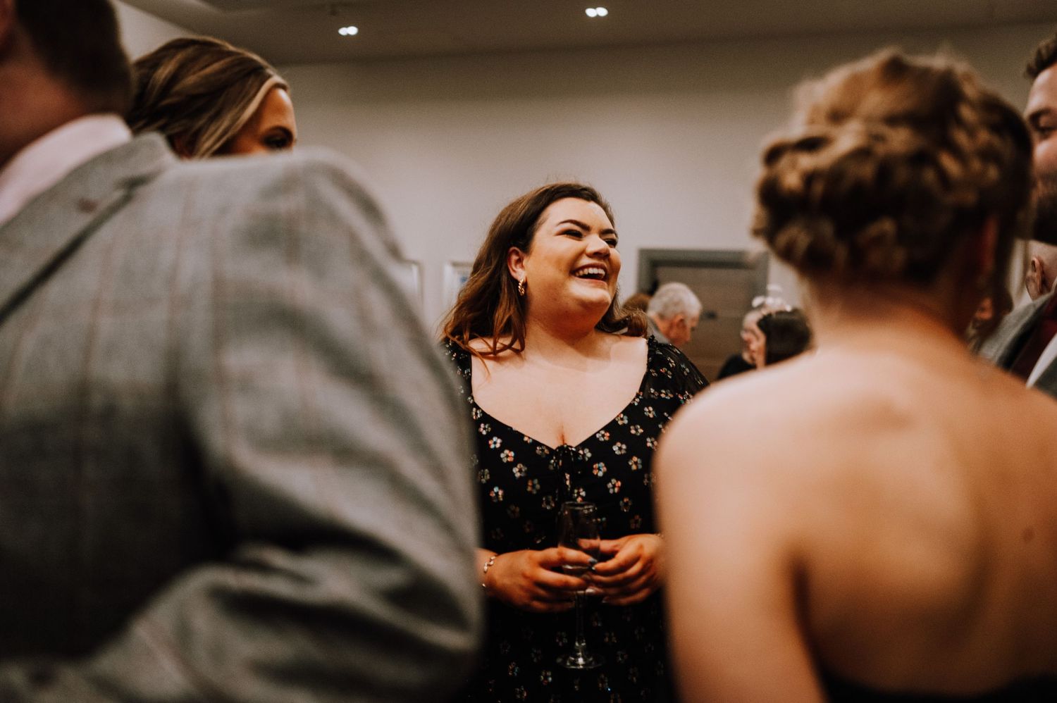 Guests share laughs during a formal indoor celebration.