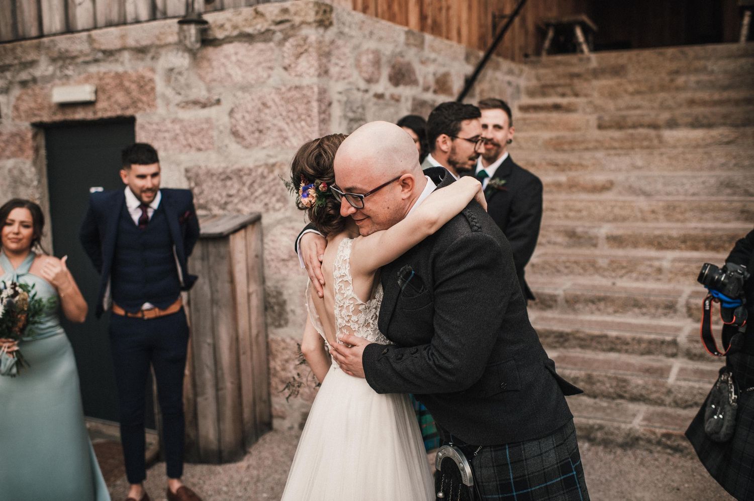 Tender wedding moments shared on stone steps of a historic building.