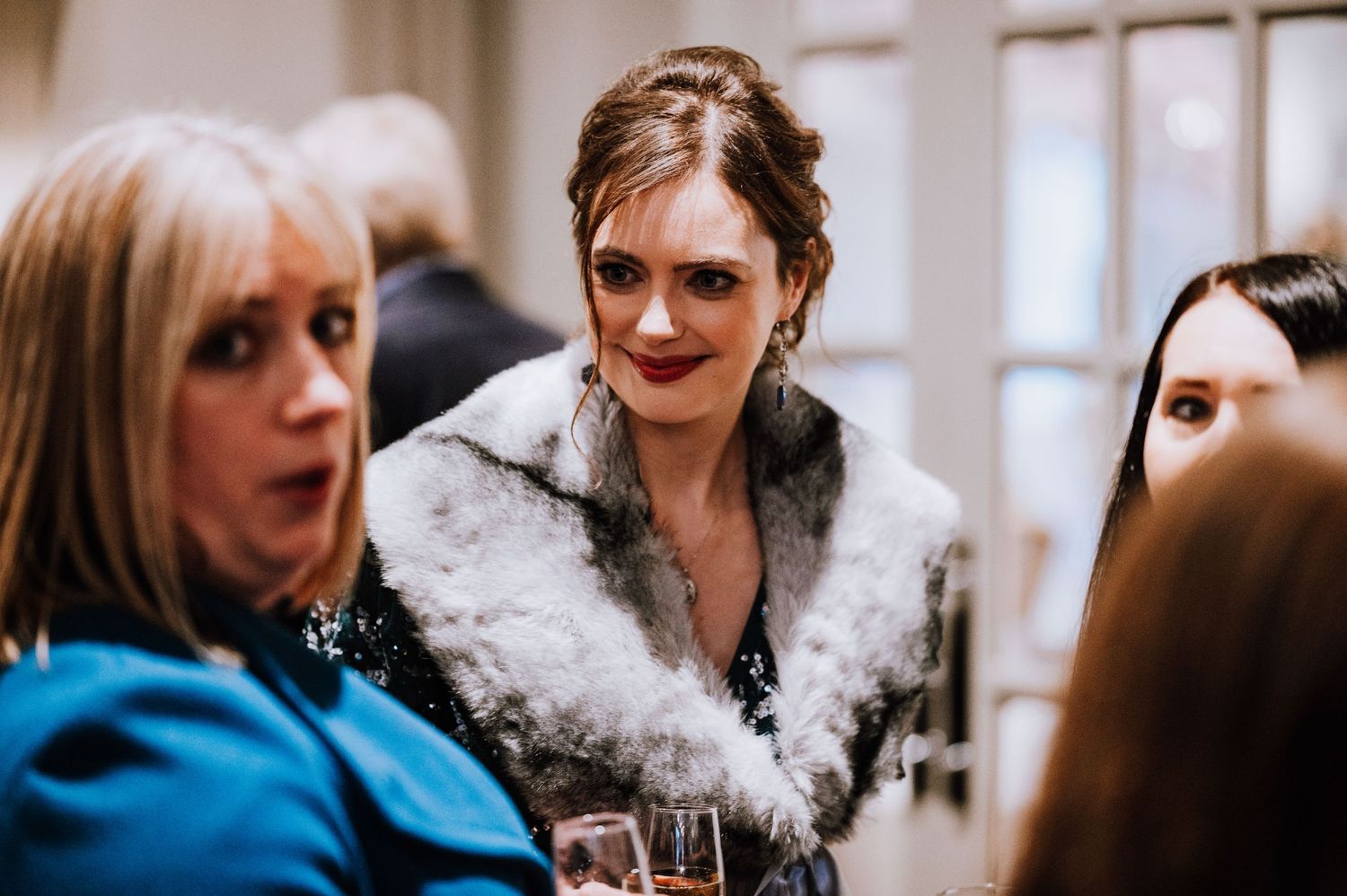 Wedding guests sharing stories and laughter during the indoor reception festivities.