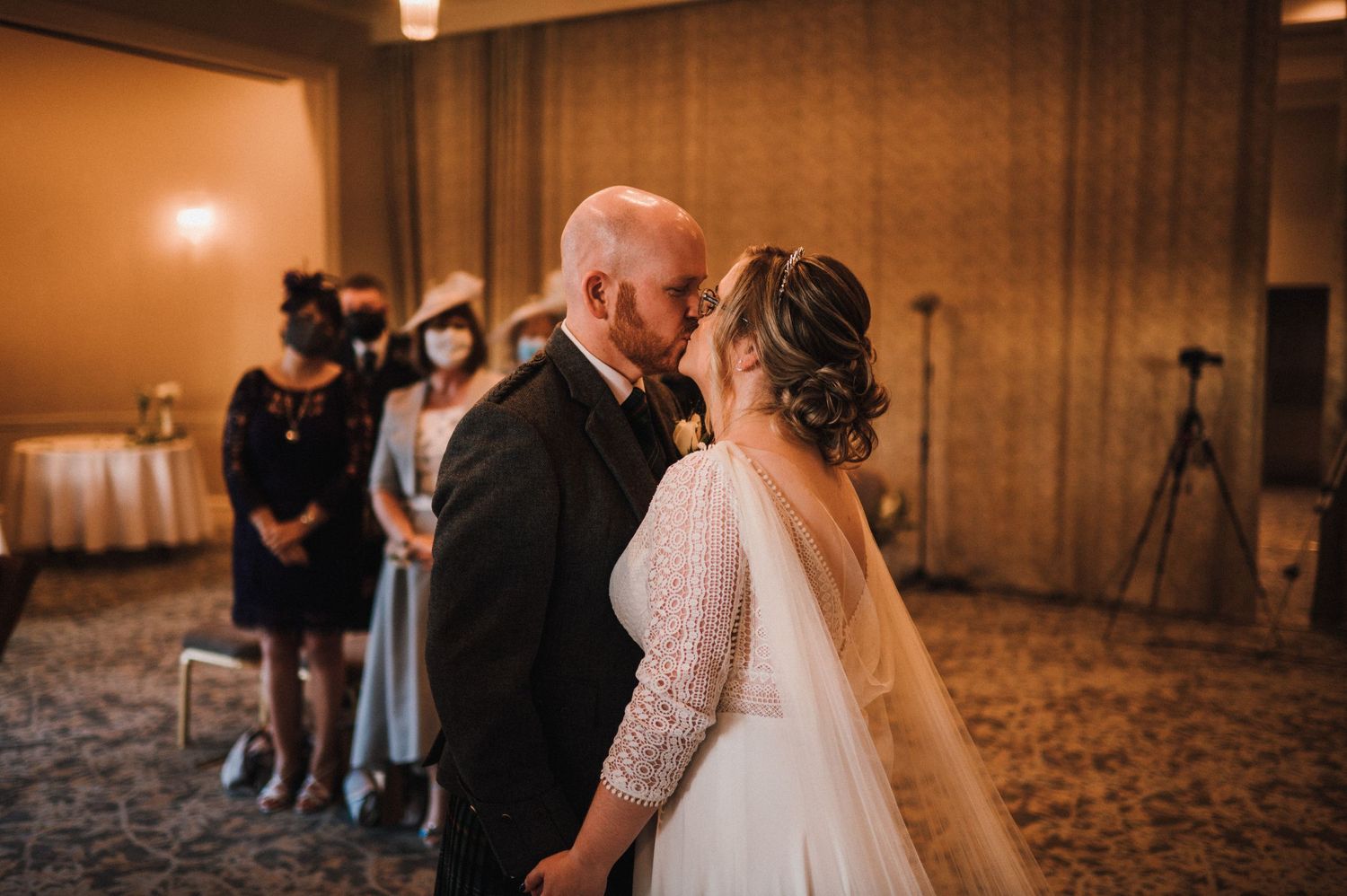 Couple sharing an intimate moment during their wedding reception in a ballroom.