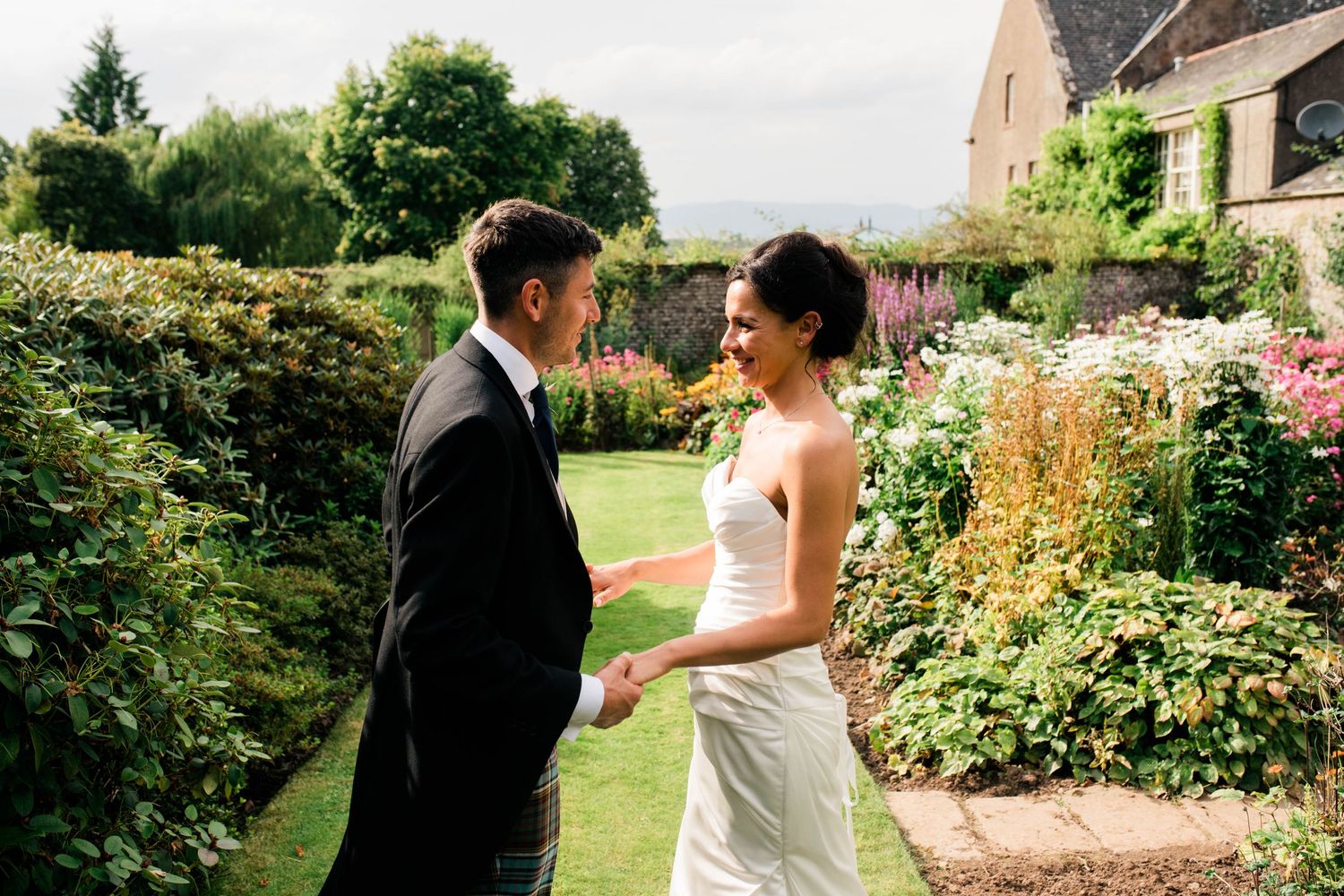 A tender moment between newlyweds in a beautiful garden setting.