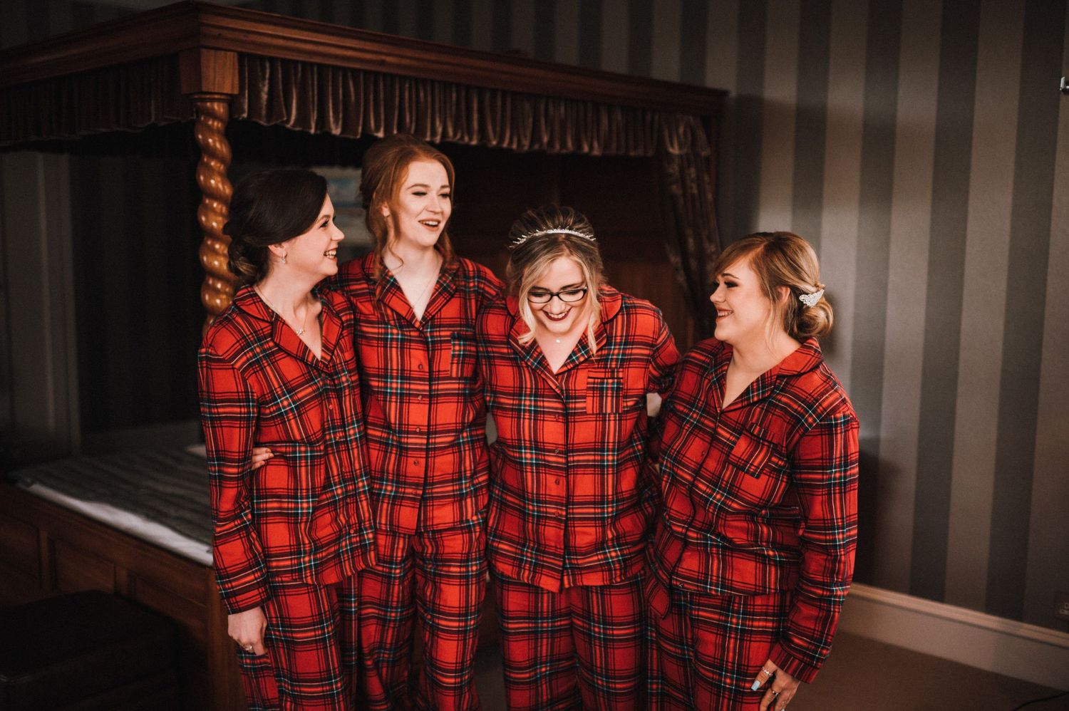Group laughing together while wearing coordinated red buffalo plaid pajamas.