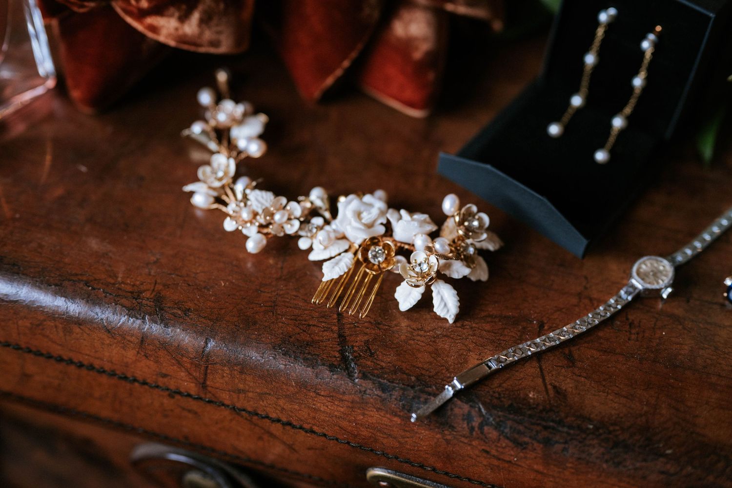 Delicate silver and crystal bridal jewelry pieces arranged on a rustic wooden surface with soft lighting.