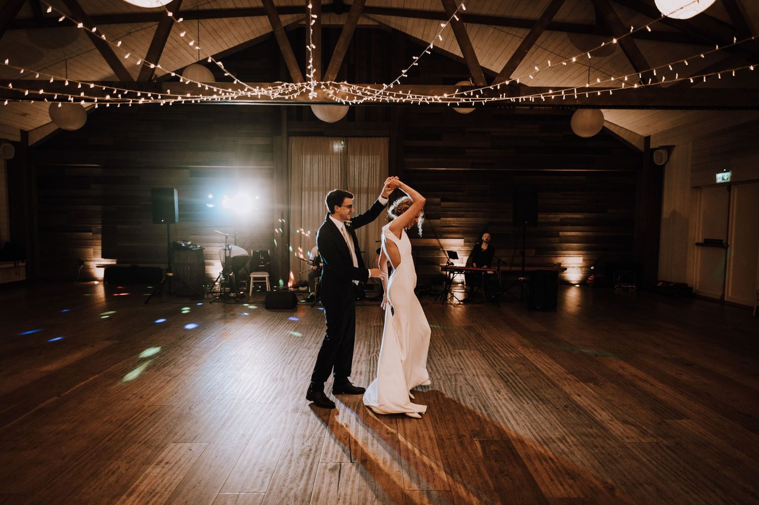 Aberdeen Wedding Photography. Couple dances in an intimate moment on darkened dance floor under string lights.