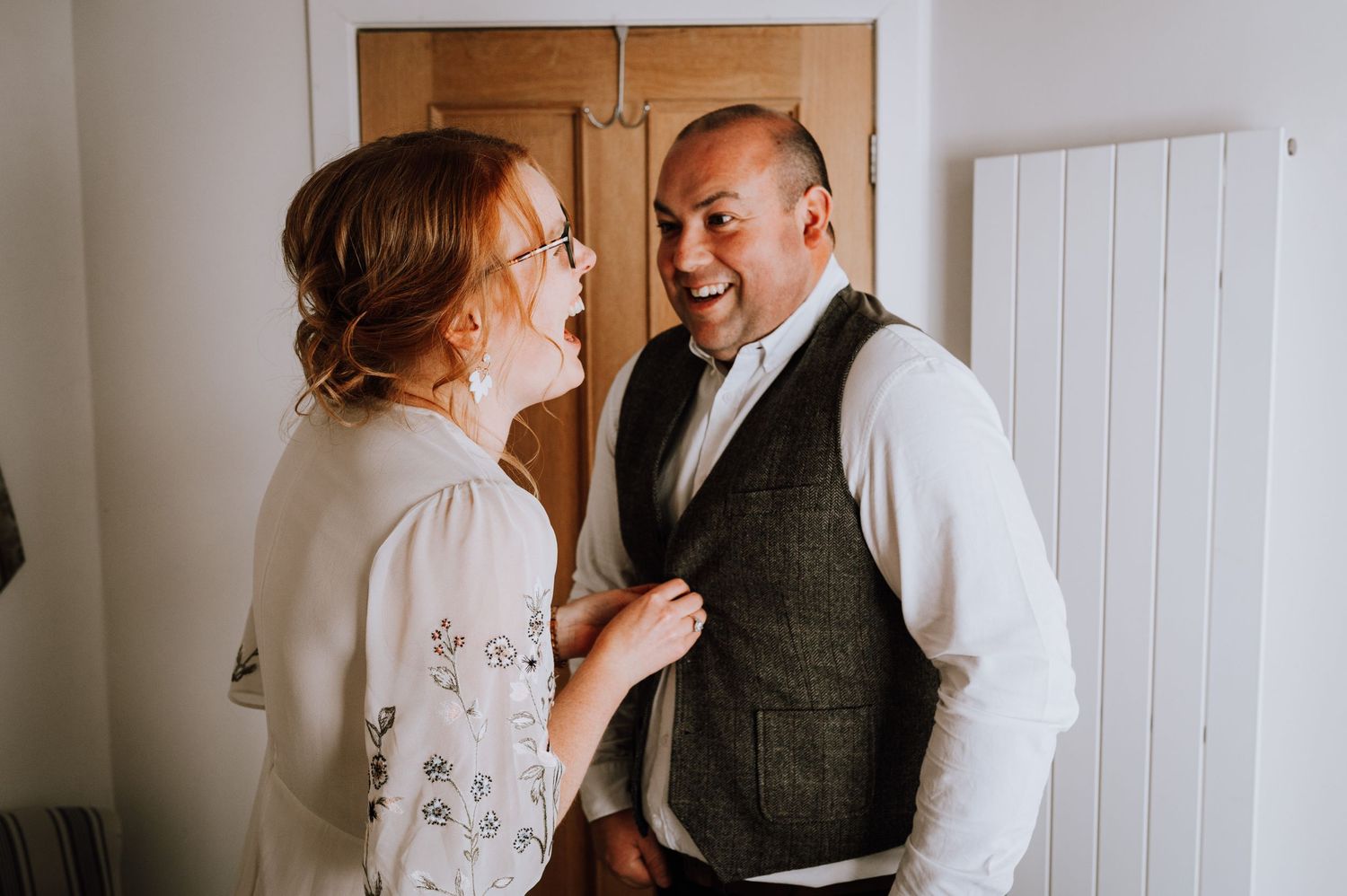Two people sharing a joyful moment in casual formal attire.
