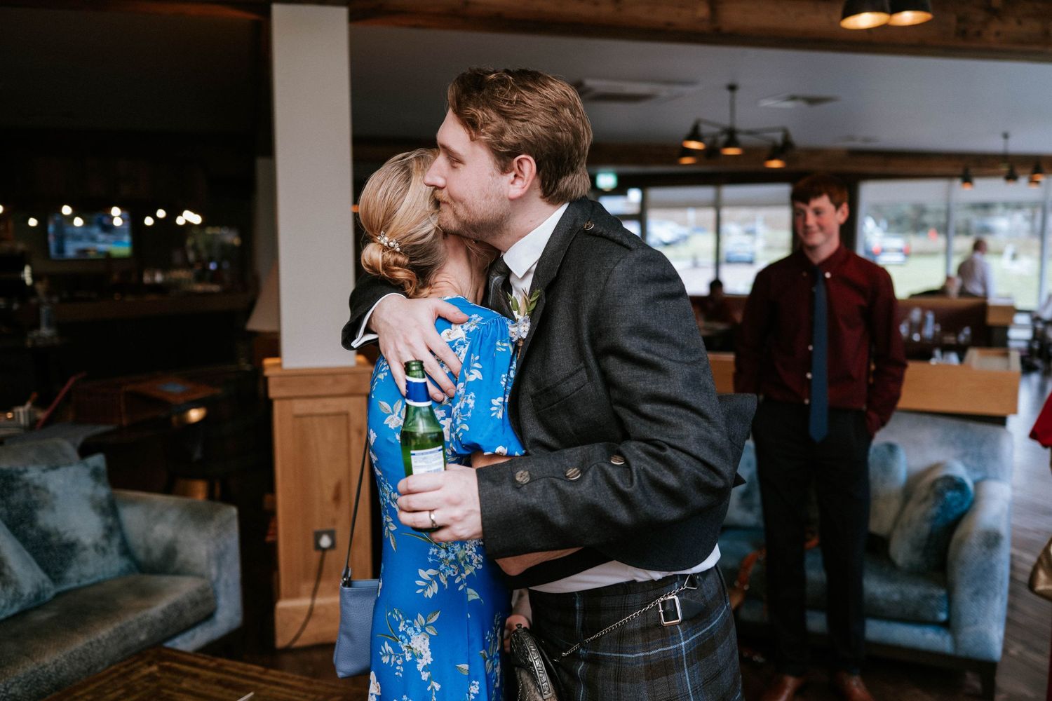 A couple shares intimate moments during an indoor wedding celebration with warm lighting and elegant decor.