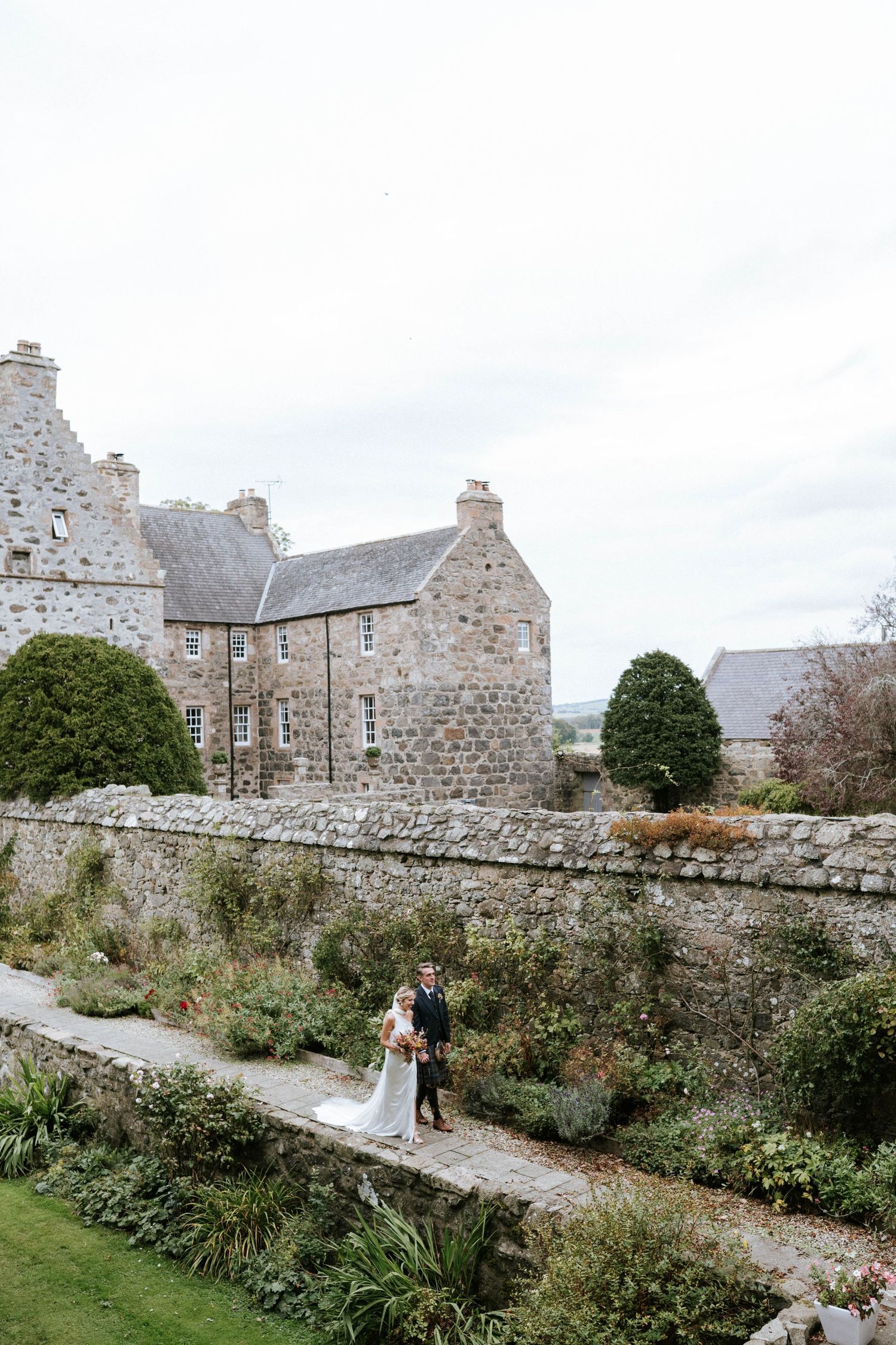 Stone castle grounds with garden path and historic architecture in Scotland.