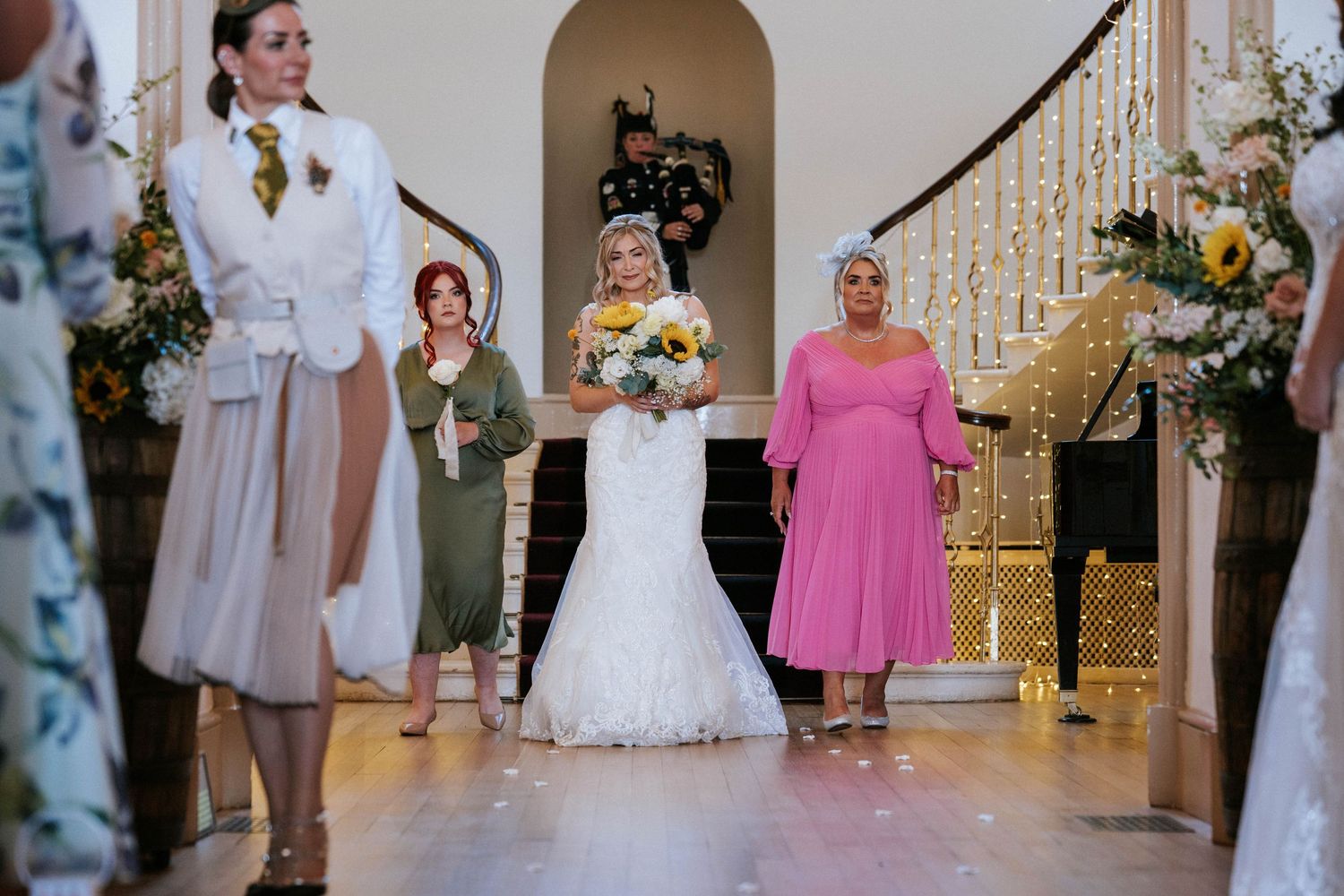 Fasque Castle Wedding Photography. Wedding party gathered in ornate venue with white and pink decor and floral arrangements.