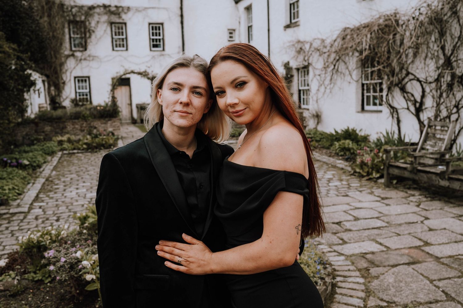 Logie House Wedding Photography. Wedding couple and party posing outside historic white stone building.