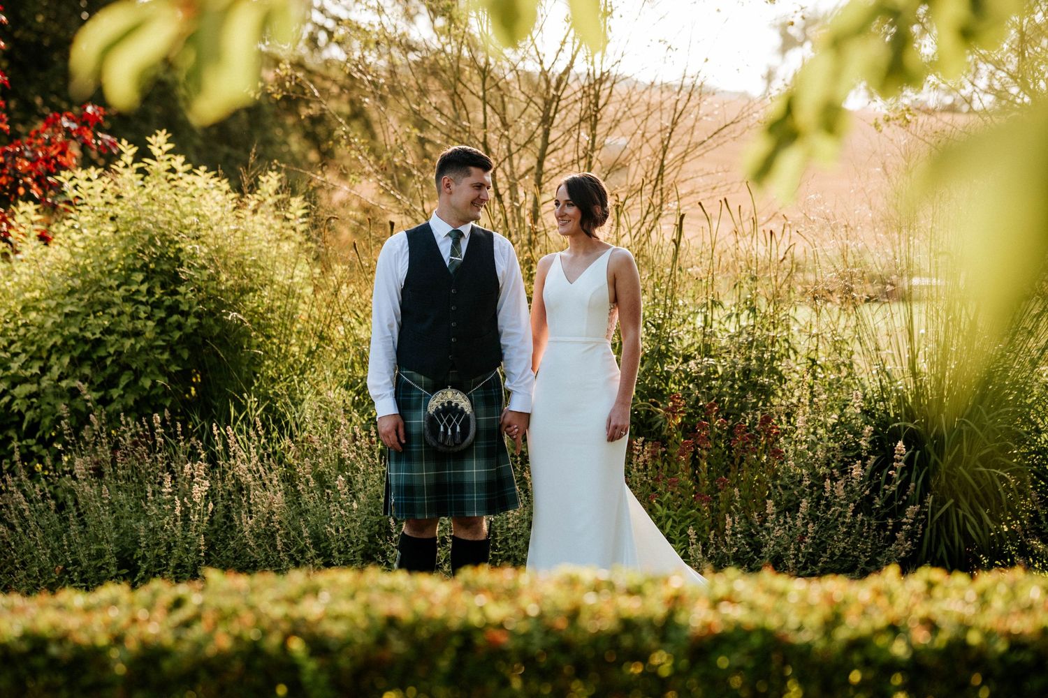 Aberdeen Wedding Photography. Couple poses for romantic wedding photos in a garden setting at sunset.