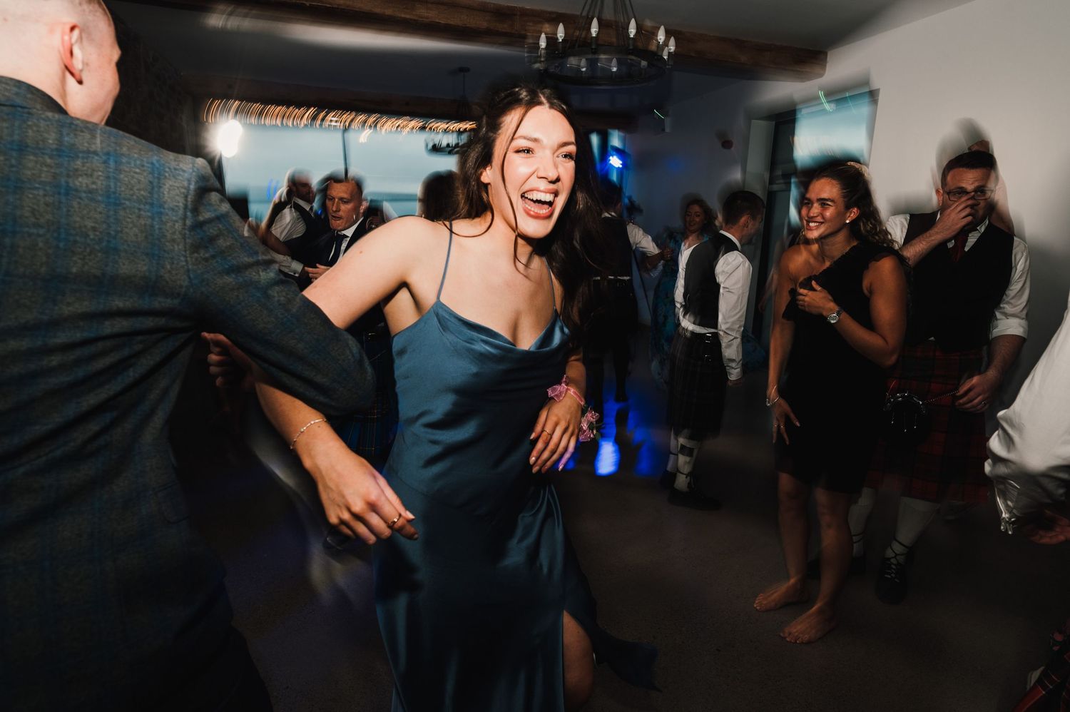 Guest dancing joyfully at an evening party in a navy dress.