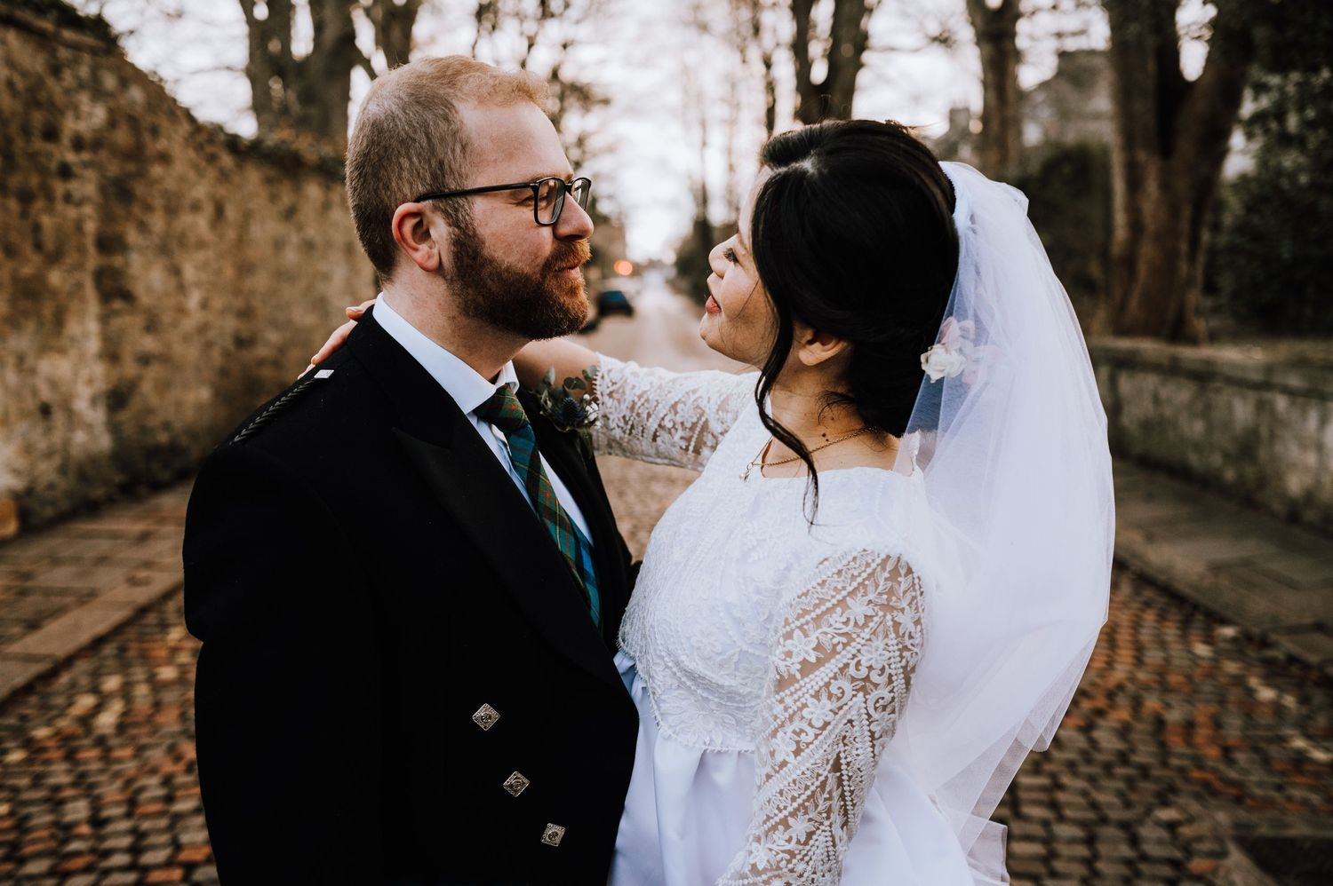 An intimate portrait of newlyweds sharing a moment on their wedding day against autumn trees.