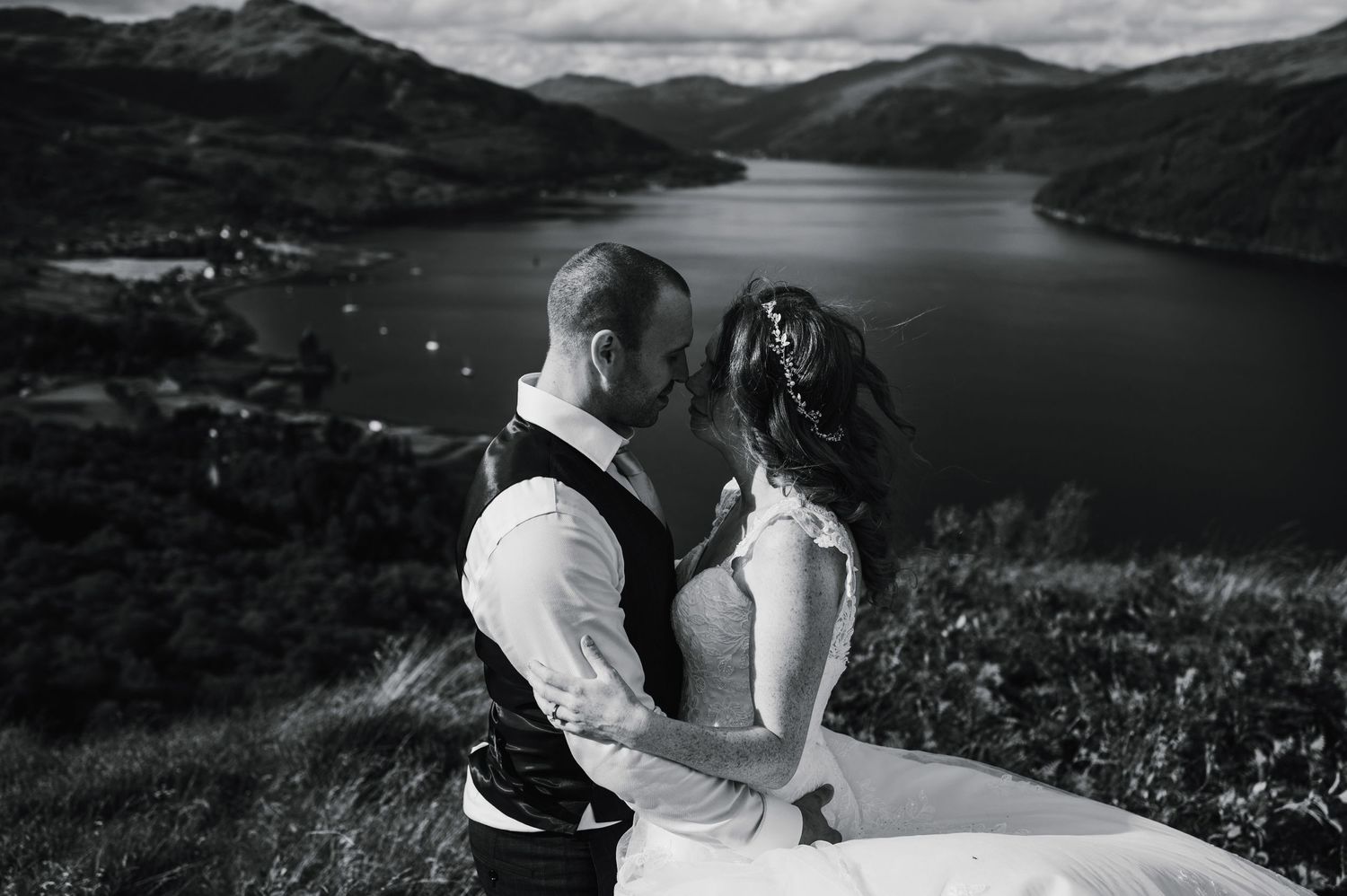 A black and white portrait overlooking a scenic mountain lake landscape.