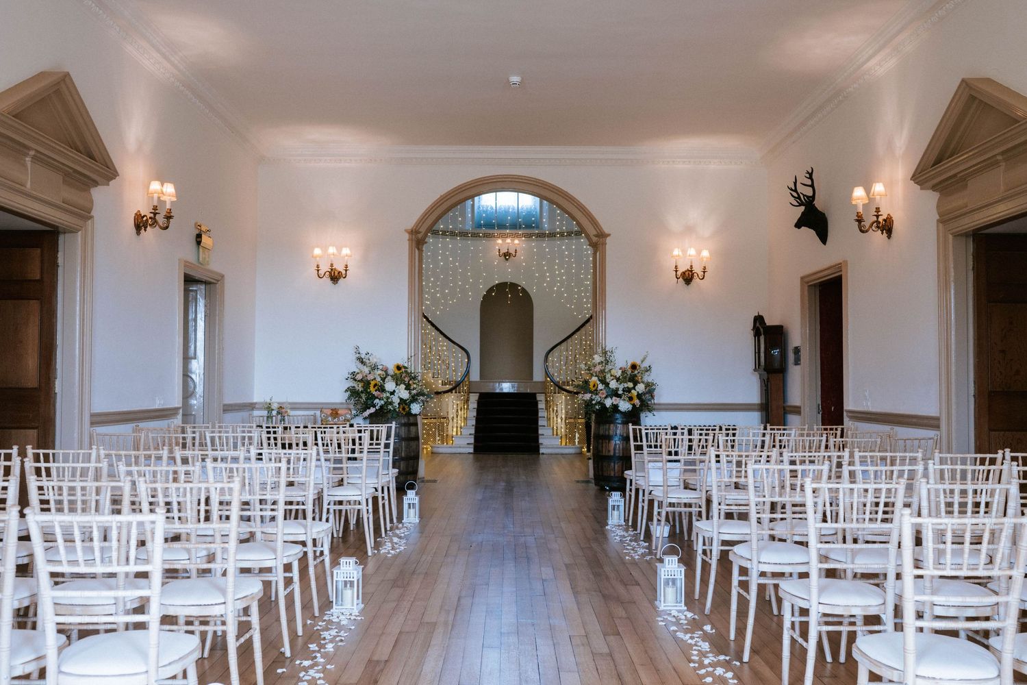Panoramic view of an elegant white wedding ceremony space with classic chiavari chairs.