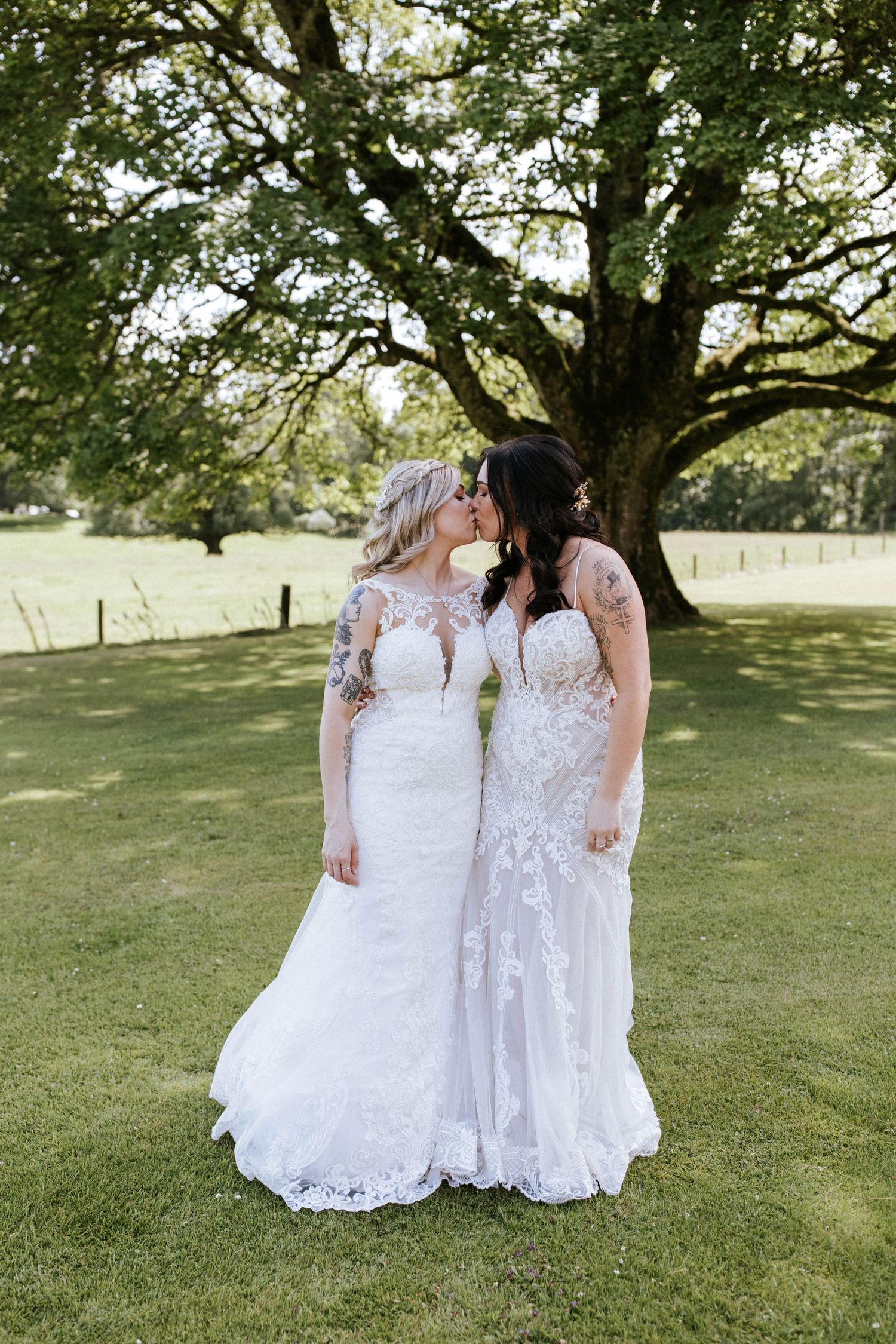 Fasque Castle Wedding Photography. Two wedding dresses shown in detail against lush green grass and trees.